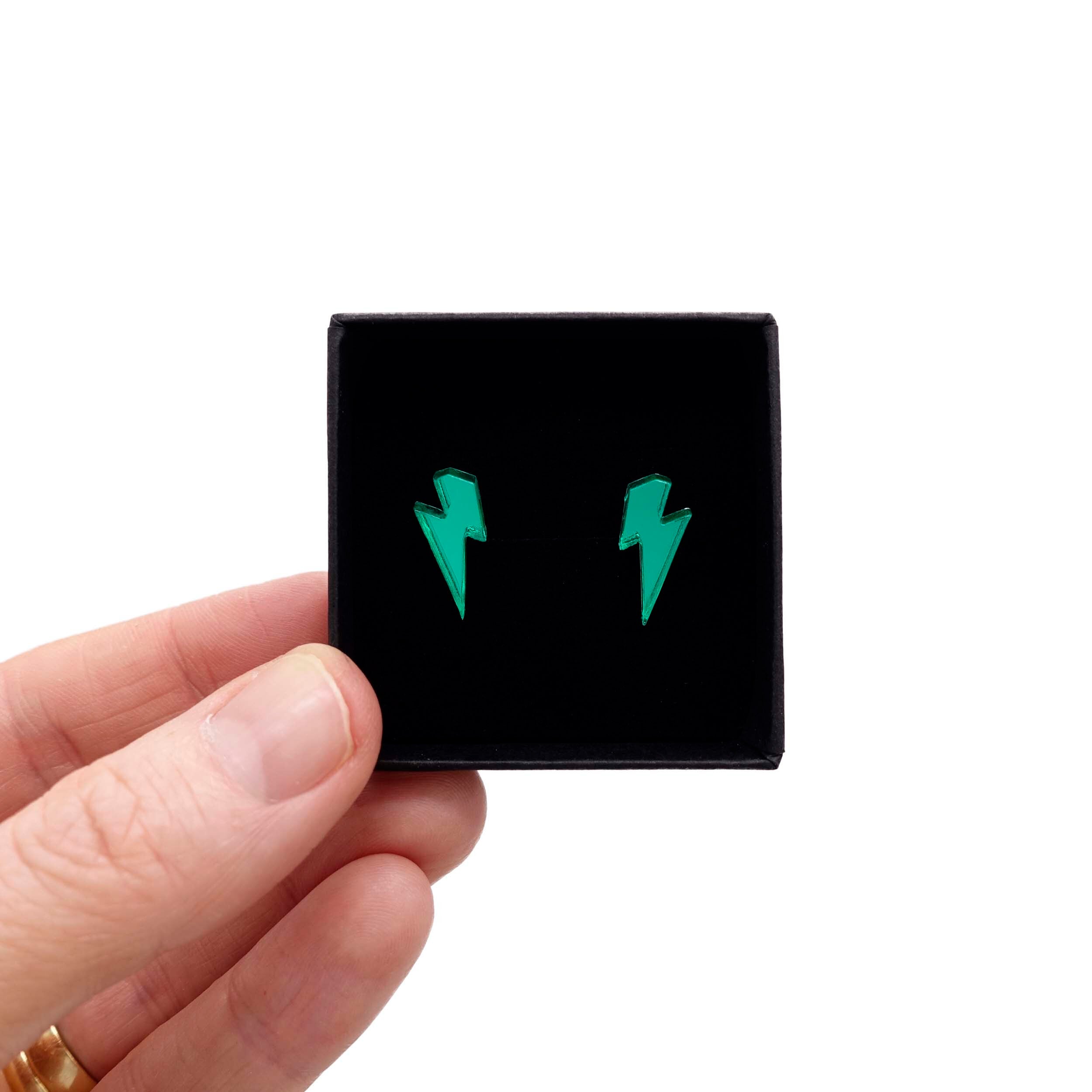 Tiny Lightning Bolt earrings in electric green mirror, shown held up in a small Wear and Resist gift box.