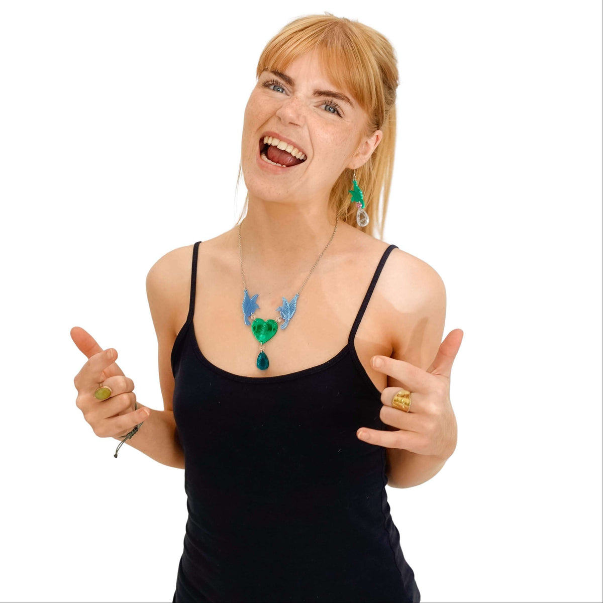 Eliza wears the Rude Birds statement necklace in blue and green with matching green earrings.