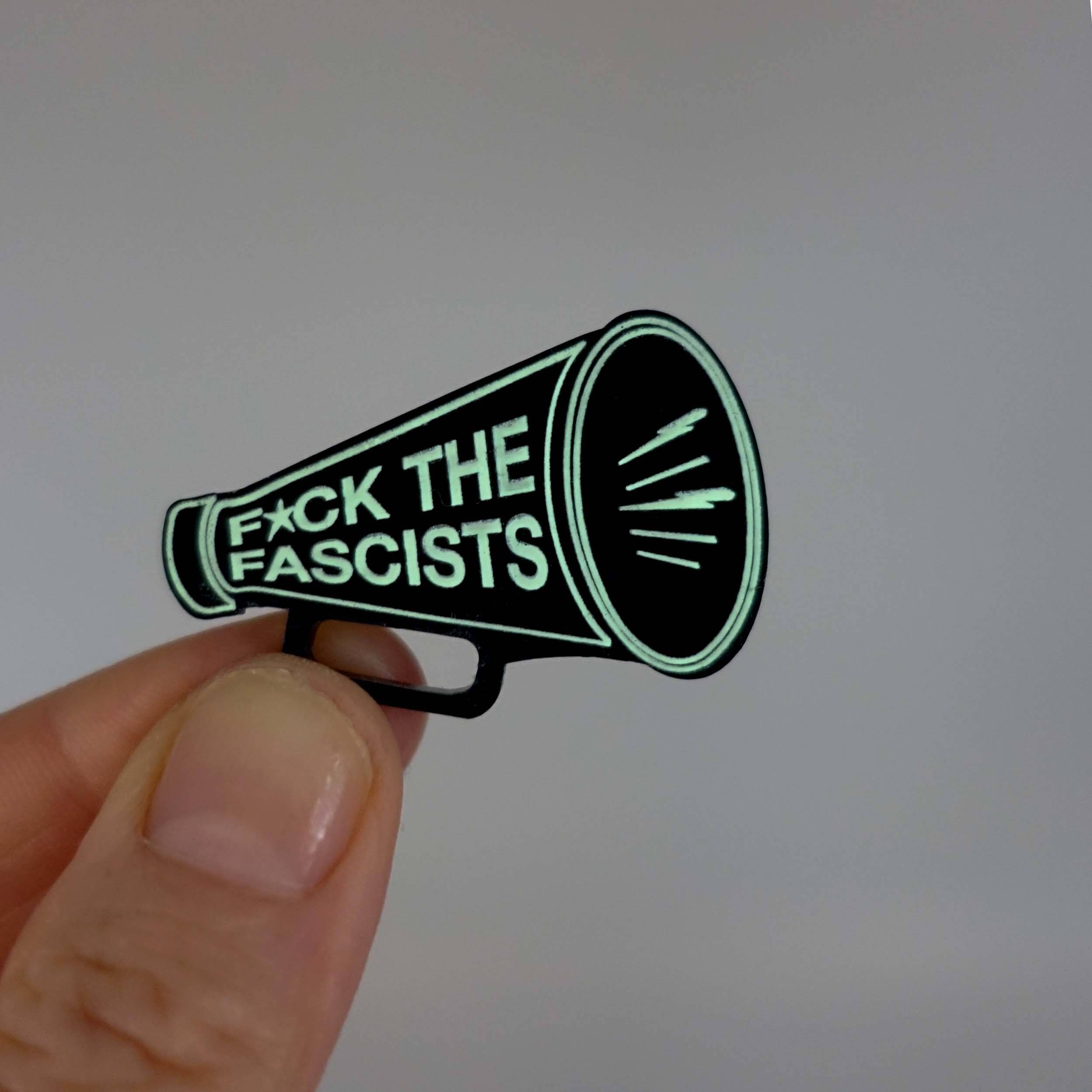 F*ck the Fascists megaphone brooch, shown glowing in the dark.