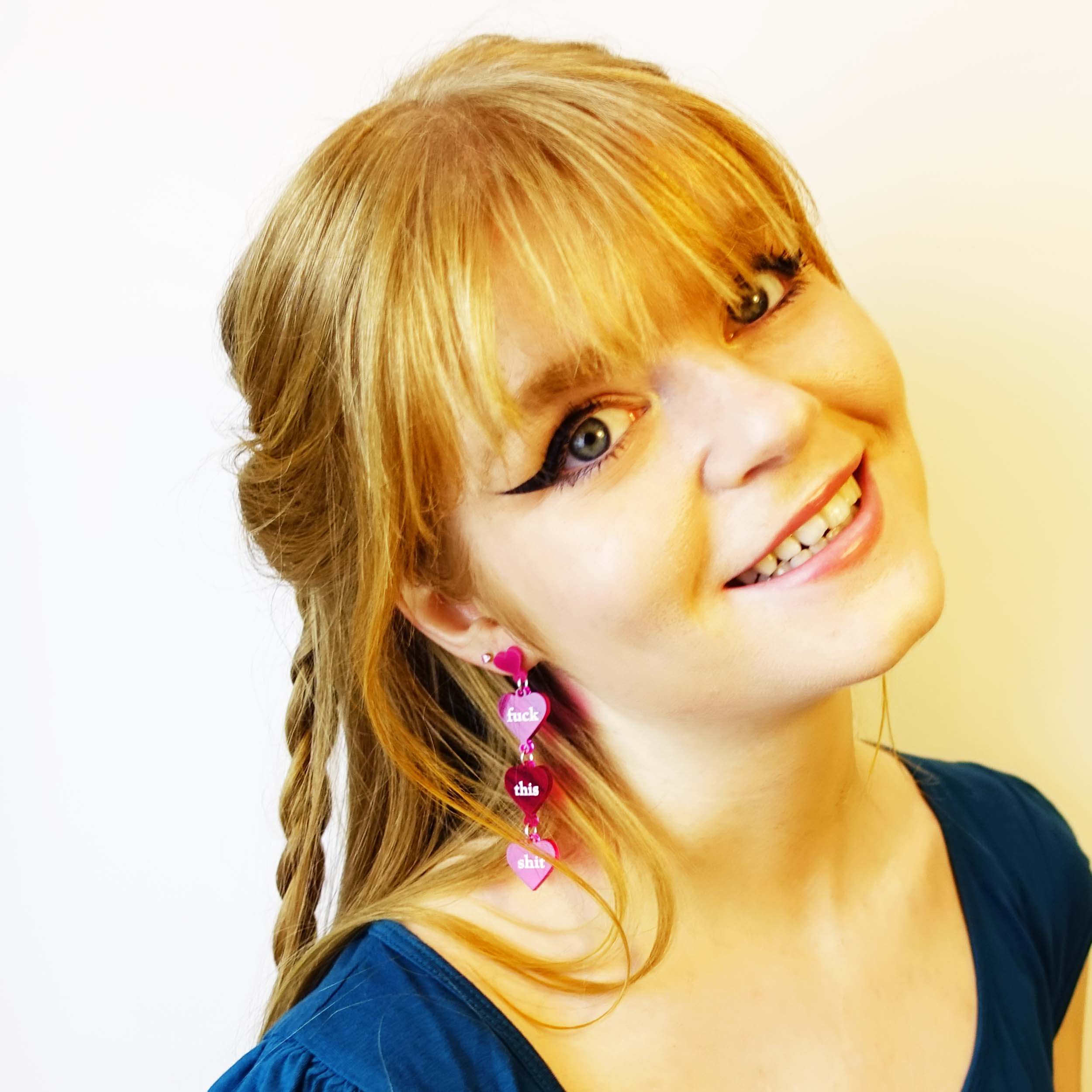 Eliza wears f*ck this sh*t earrings in neon pink.