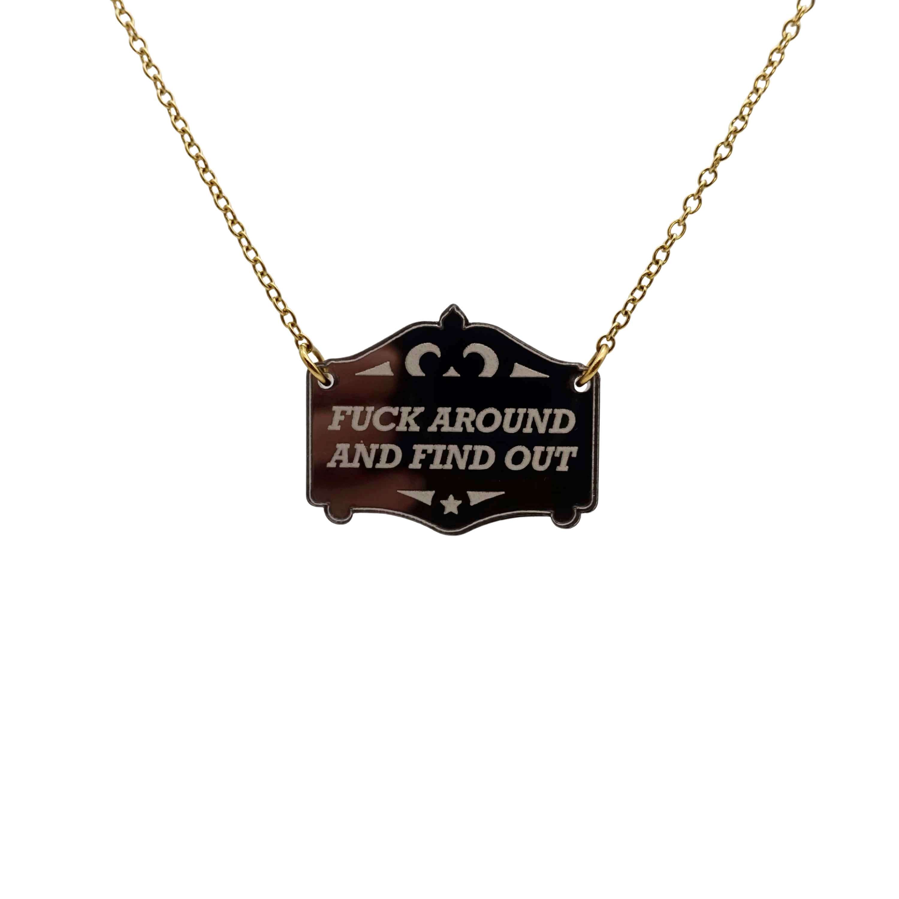 F*ck around and find out mirror cowboy necklace in bronze, shown hanging on a gold-plated stainless steel chain.