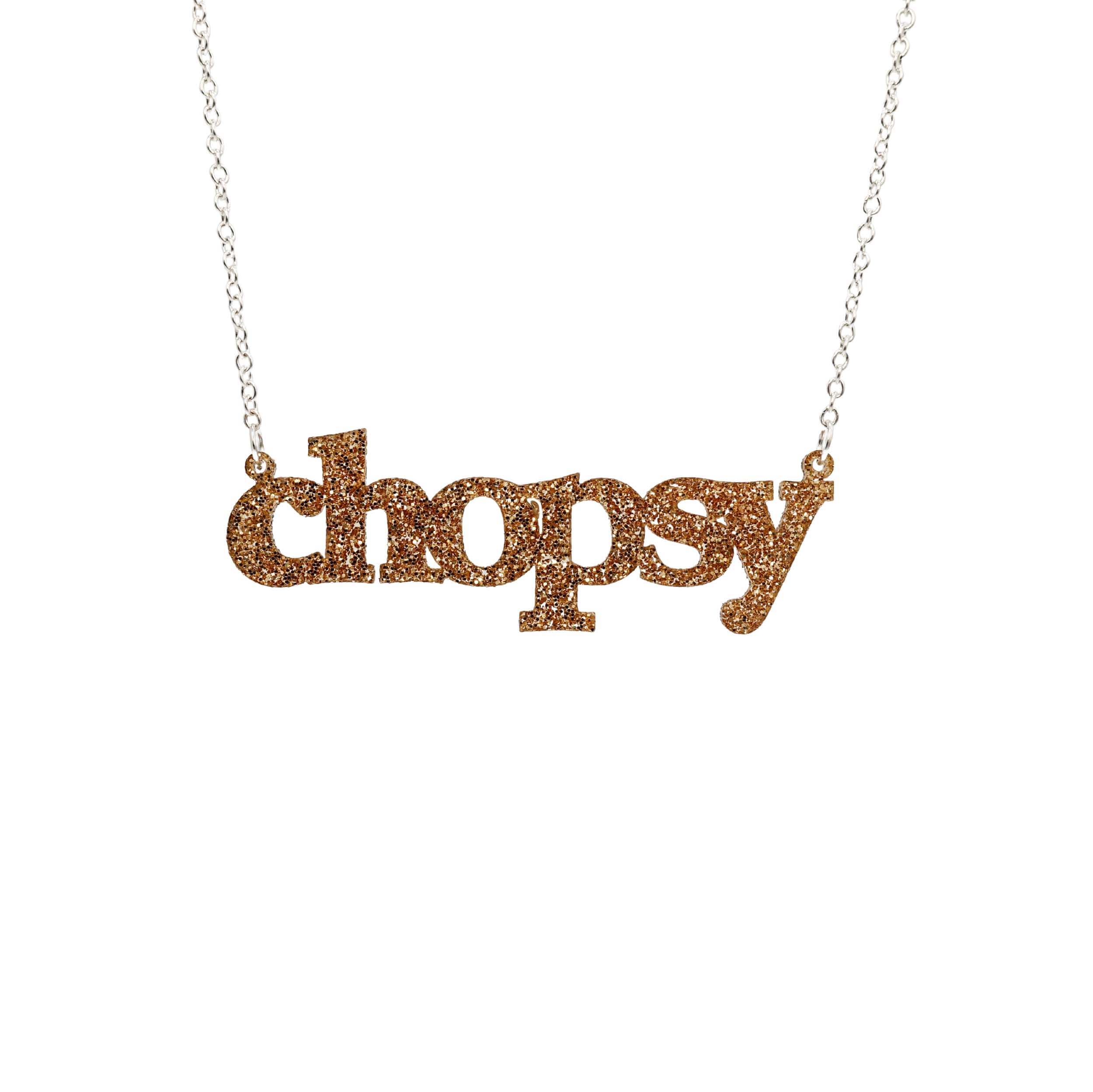 Gold glitter Chopsy necklace shown hanging against a white backround.