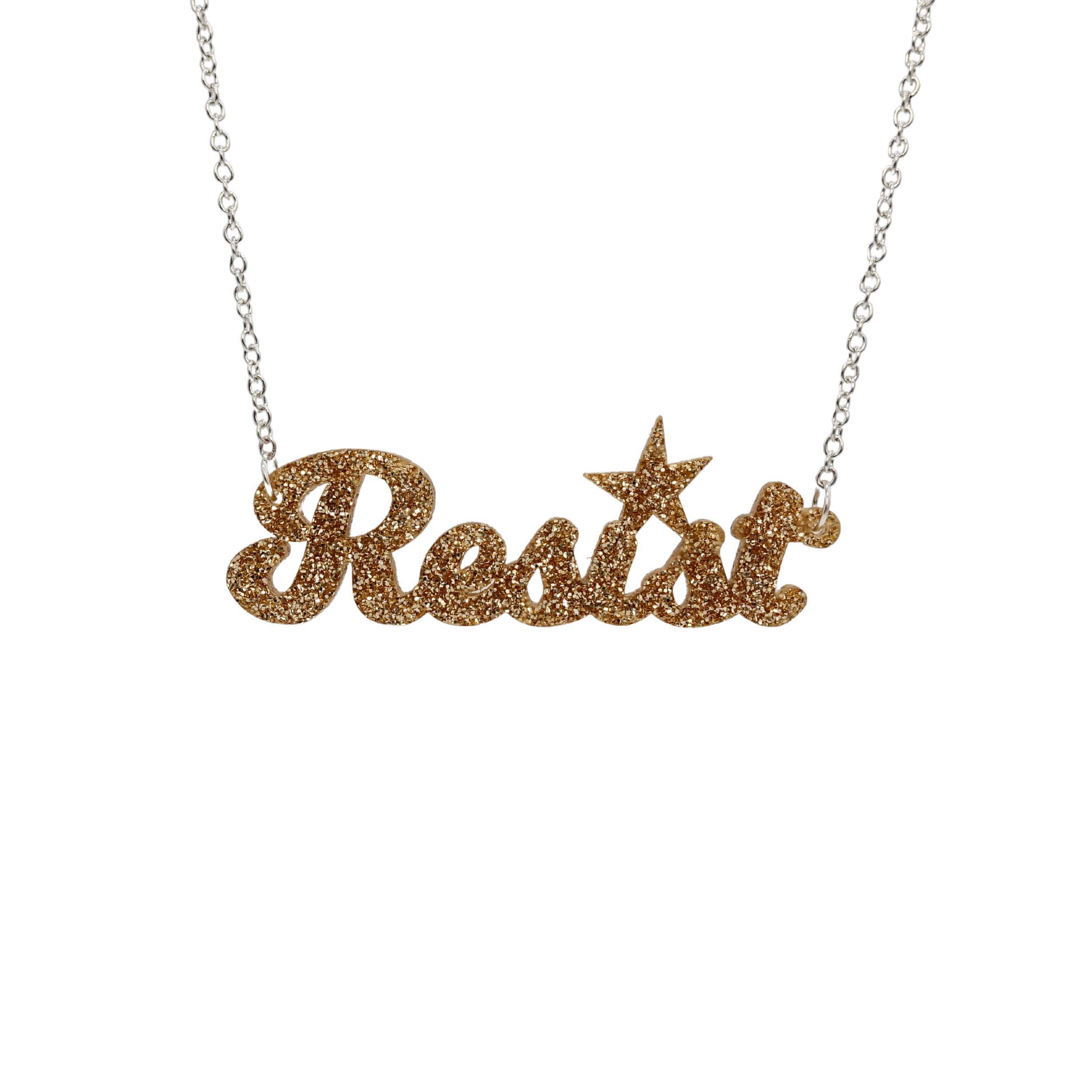 A 'Resist' necklace in gold glitter shown hanging against a white background.