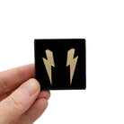 Medium Lightning Bolt earrings in gold mirror, shown held up in a small Wear and Resist gift box.
