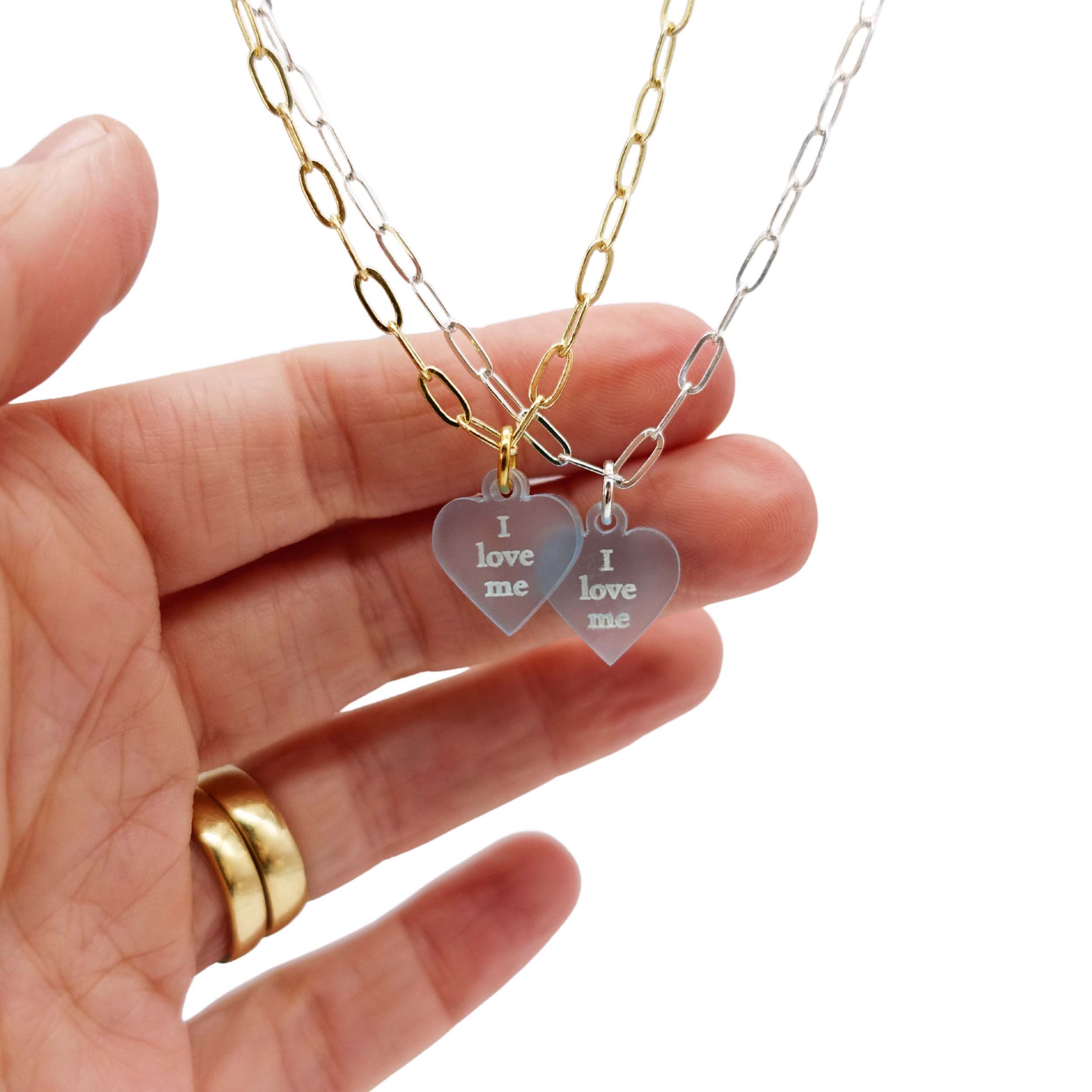 I love me glow in the dark choker and bracelet on a choice of silver or gold plated delicate paperclip chain, shown hanging with my hand behind to show the luminosity of the frosted material.