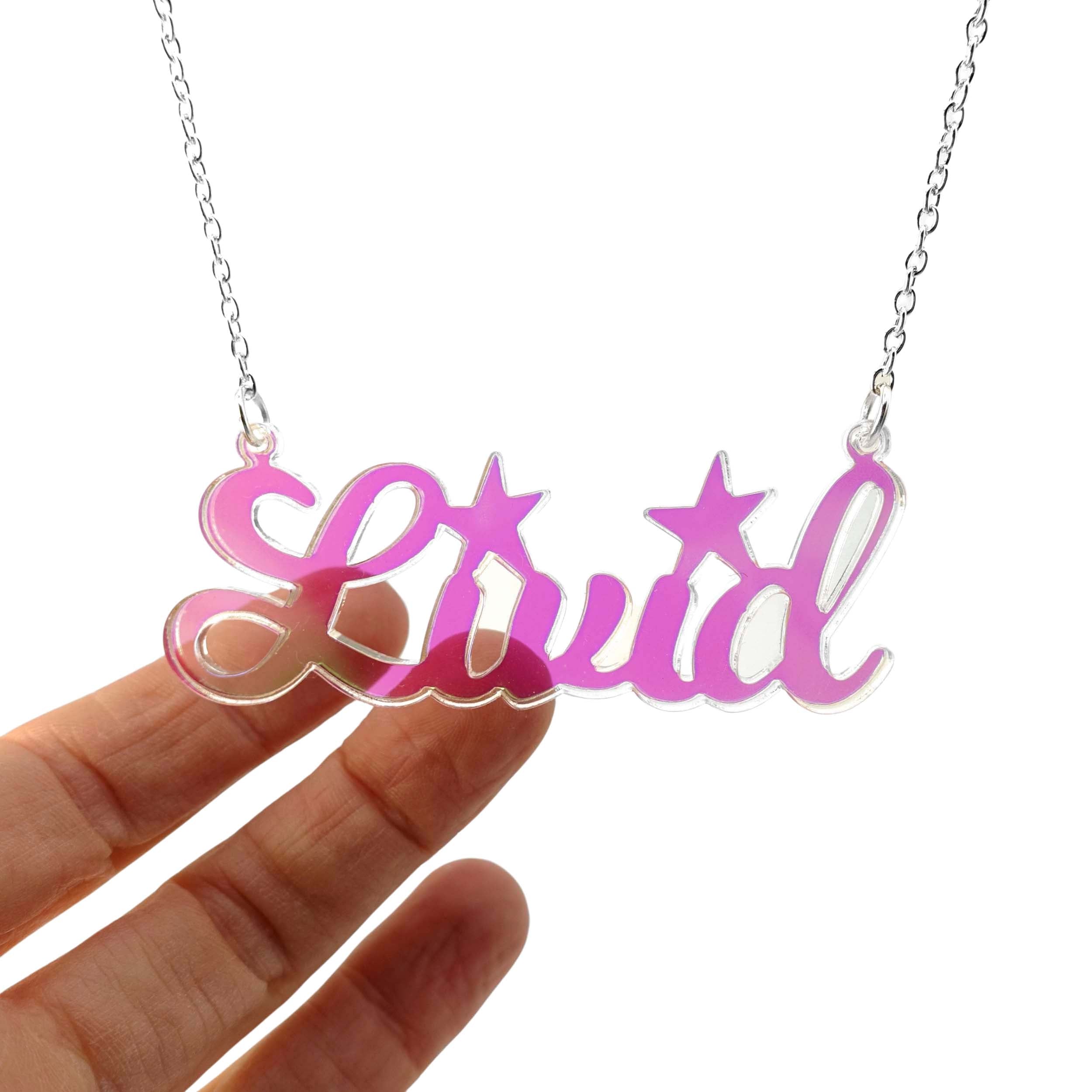 Livid necklace in iridescent shown hanging on a white background with my hand behind.