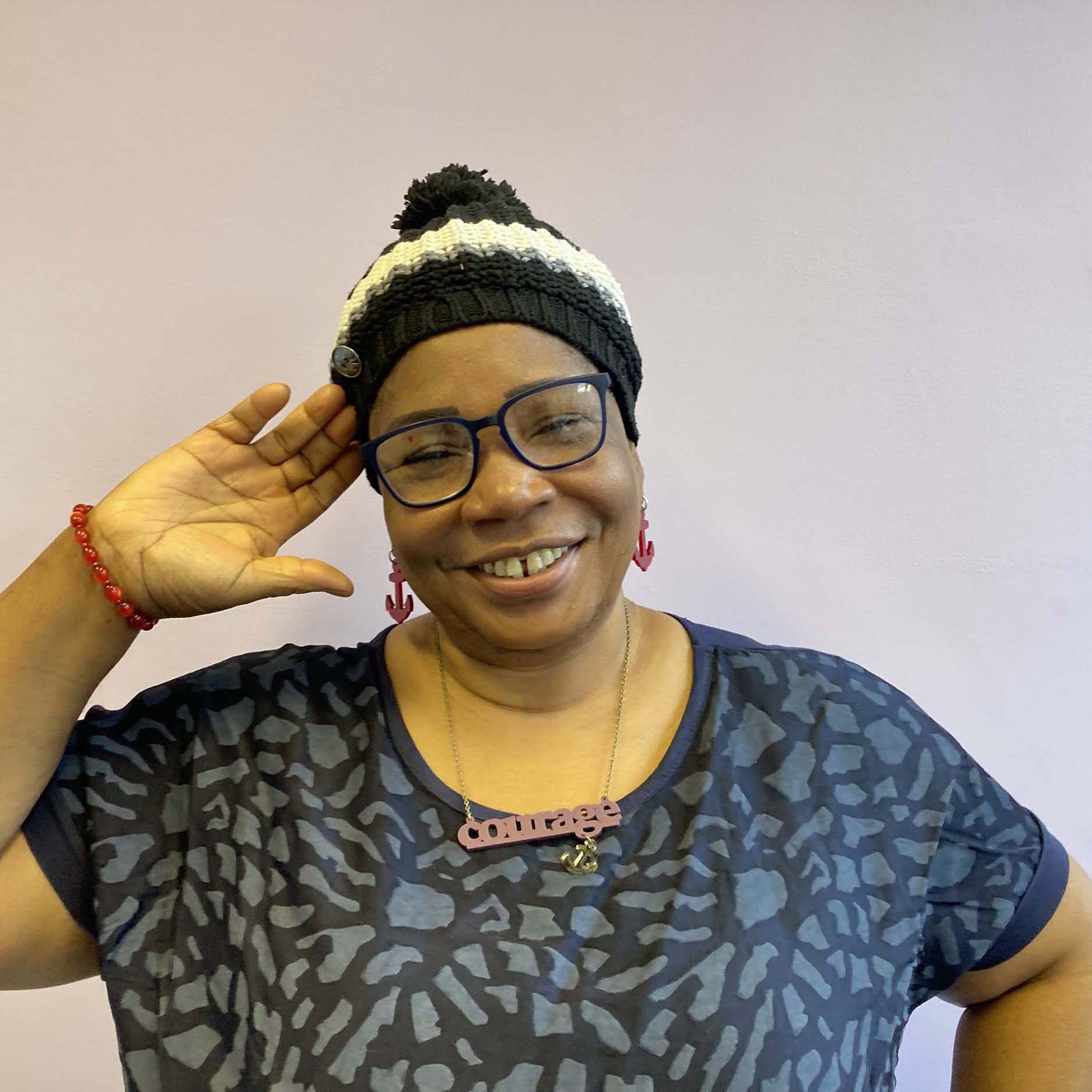 A member of Women for Refugee Women models the Courage and Hold Fast anchor earrings in ruby red and a Courage necklace with Hold Fast anchor in carmine and gold. Wear and Resist has supported this incredible charity for many years.