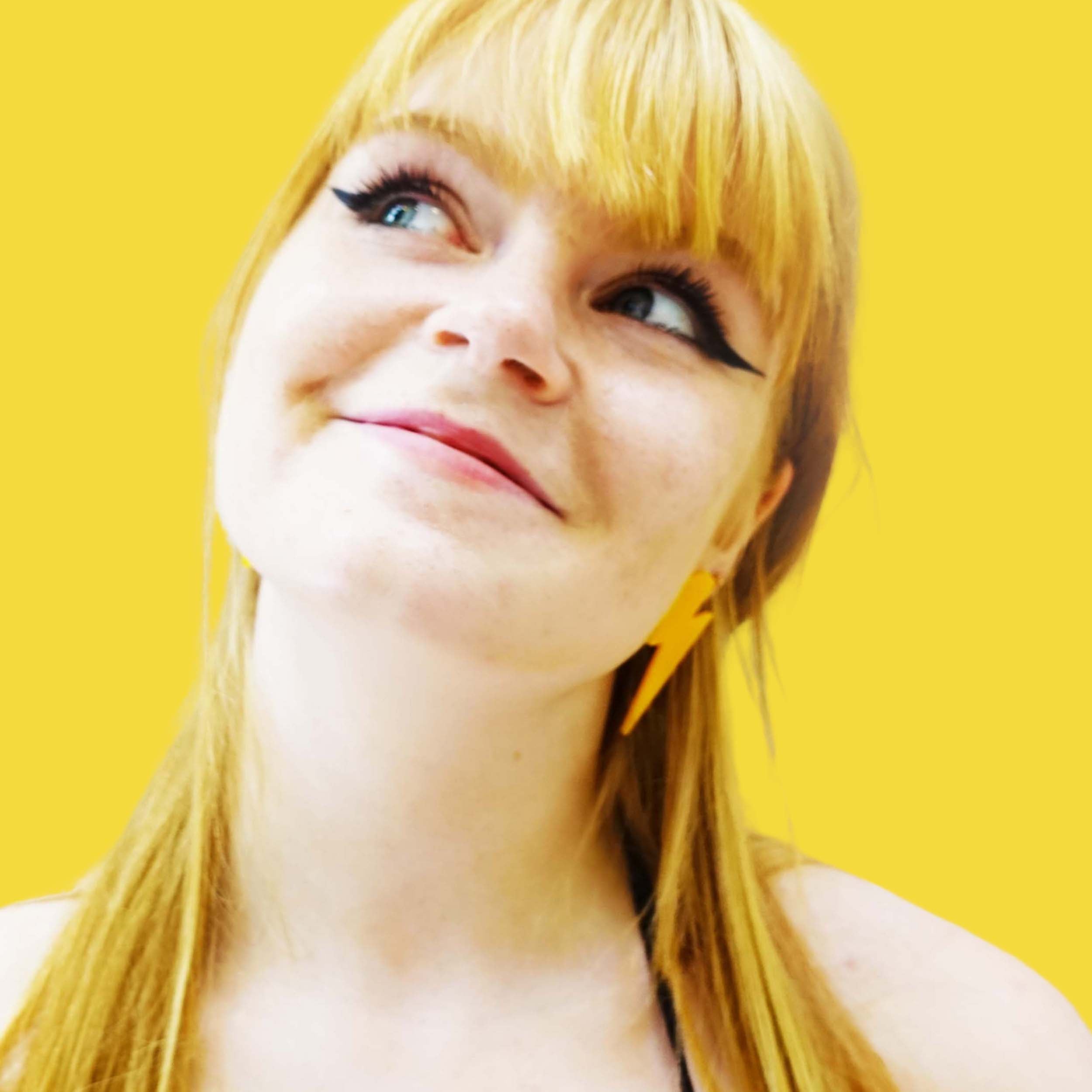 Eliza wears large Lightning Bolt earrings in sunflower yellow.