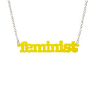 Matte lemon Feminist necklace shown hanging on a white background.