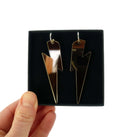 Massive Lightning Bolt hoop earrings in bronze mirror, shown held up in a Wear and Resist gift box.