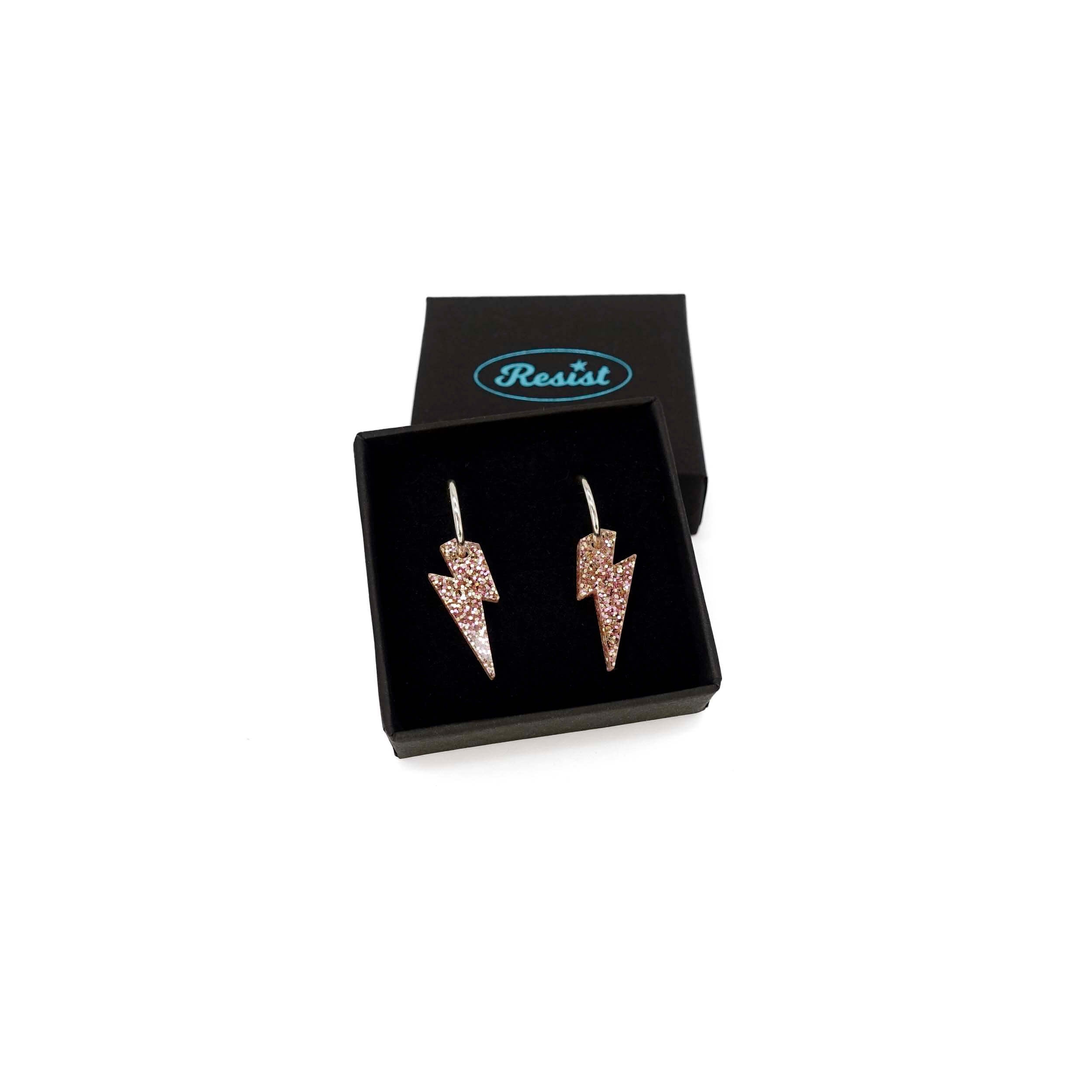 Lightning bolt hoop earrings in pink fizz glitter on silver-plated hoops, shown in a smallWear and Resist gift box.