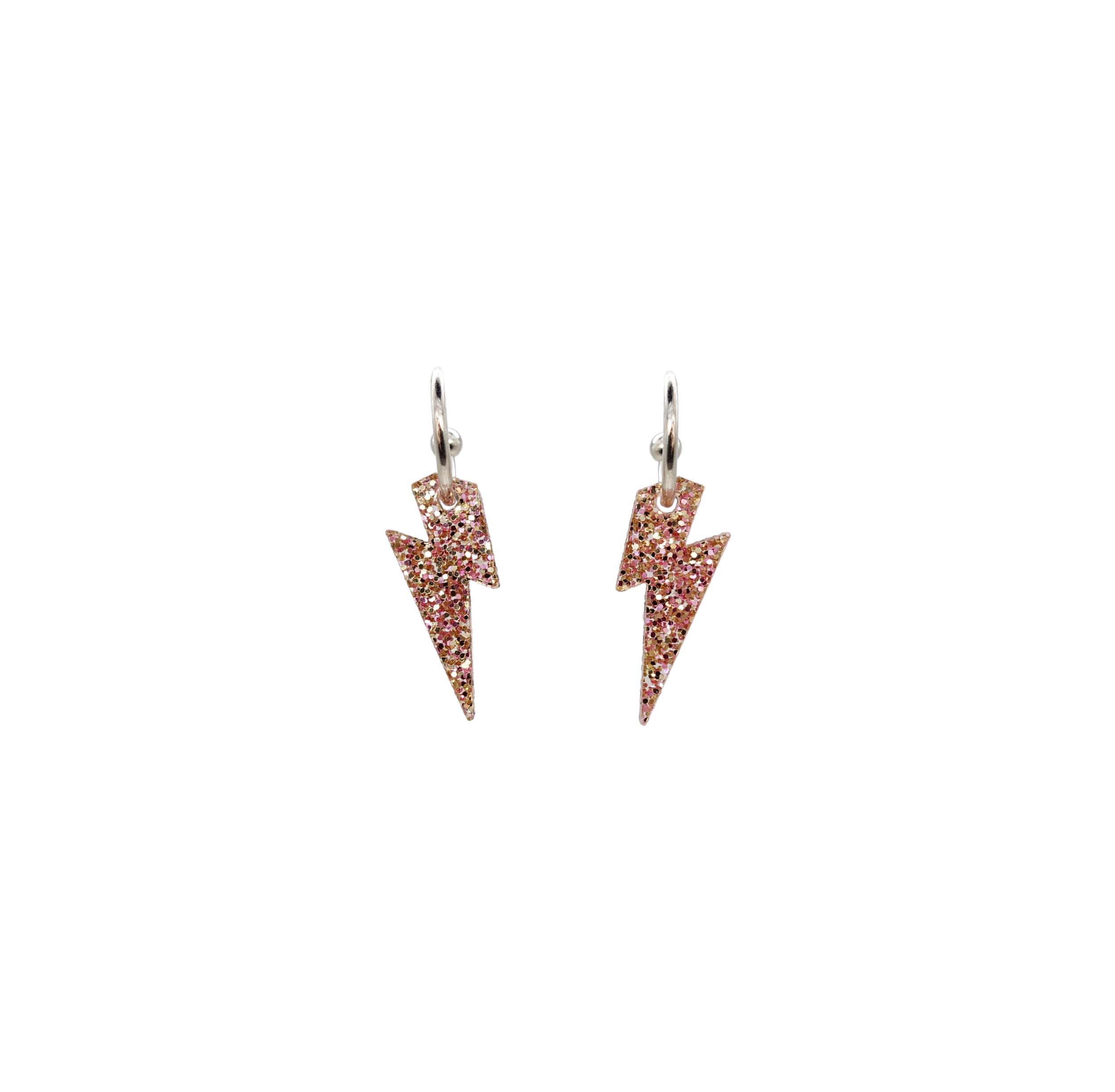 Lightning bolt hoop earrings in pink fizz glitter on silver-plated hoops, shown hanging against a white background.