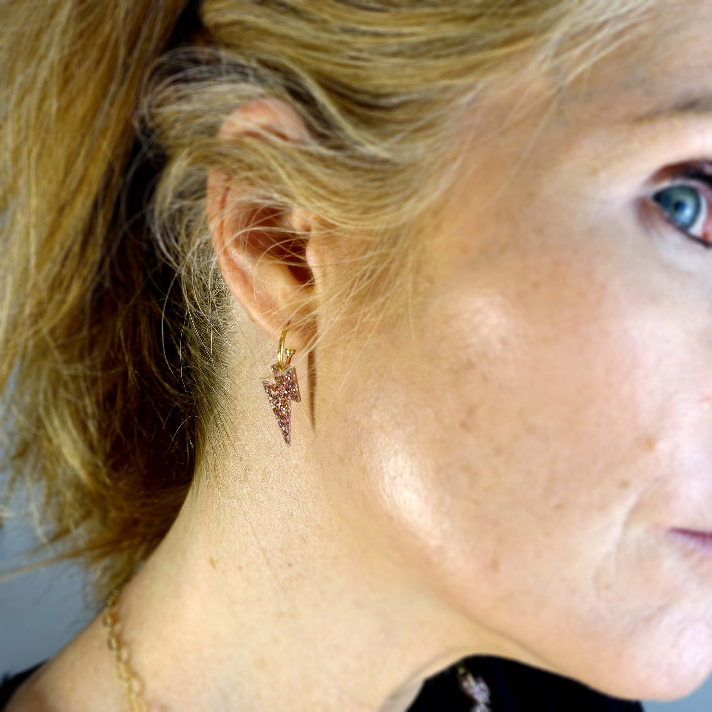 Sarah Day wears Lightning Bolt hoop earrings in pink fizz glitter.