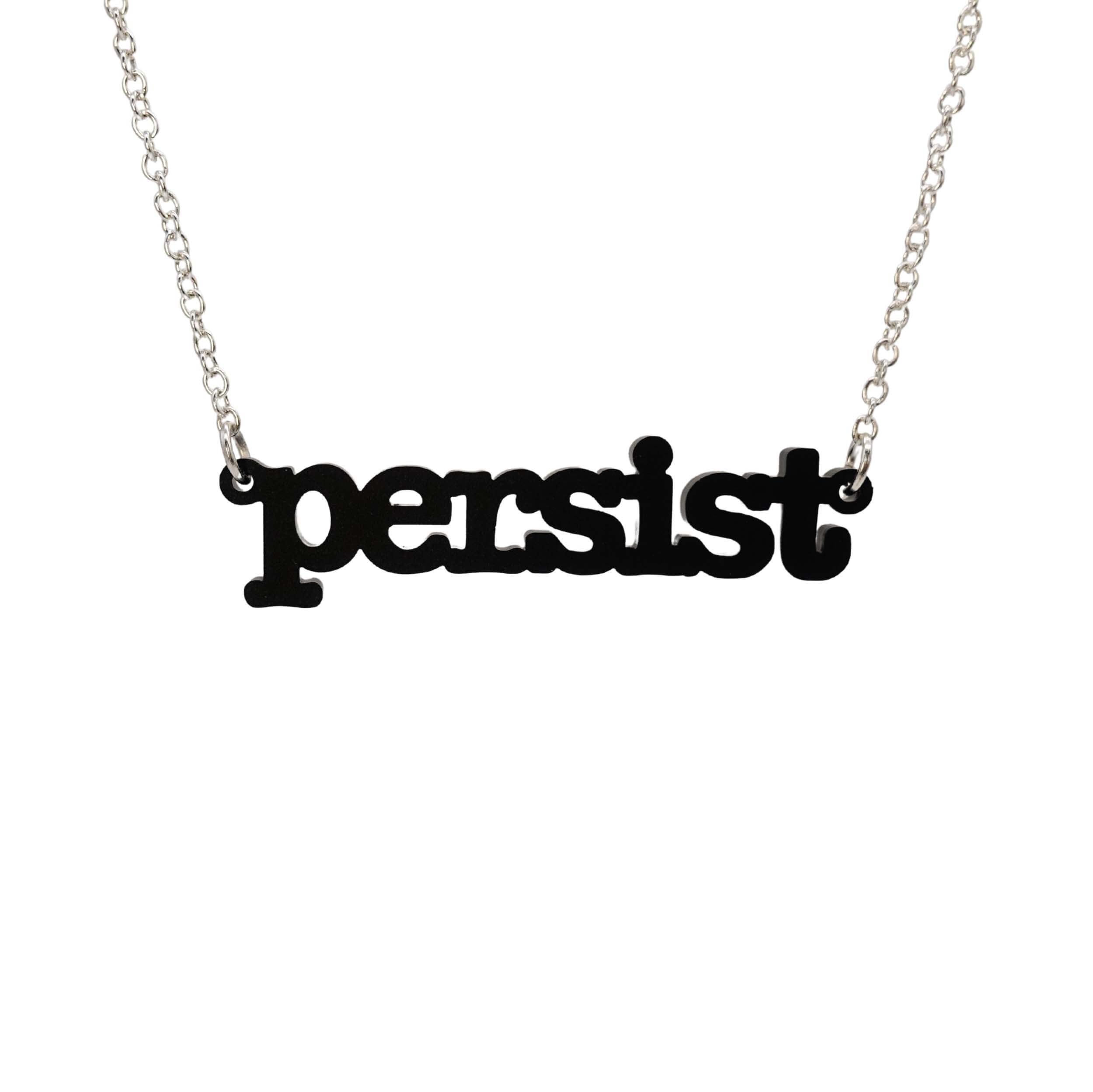 Matte black Persist necklace in typewriter font hanging on a silver chain against a white background.