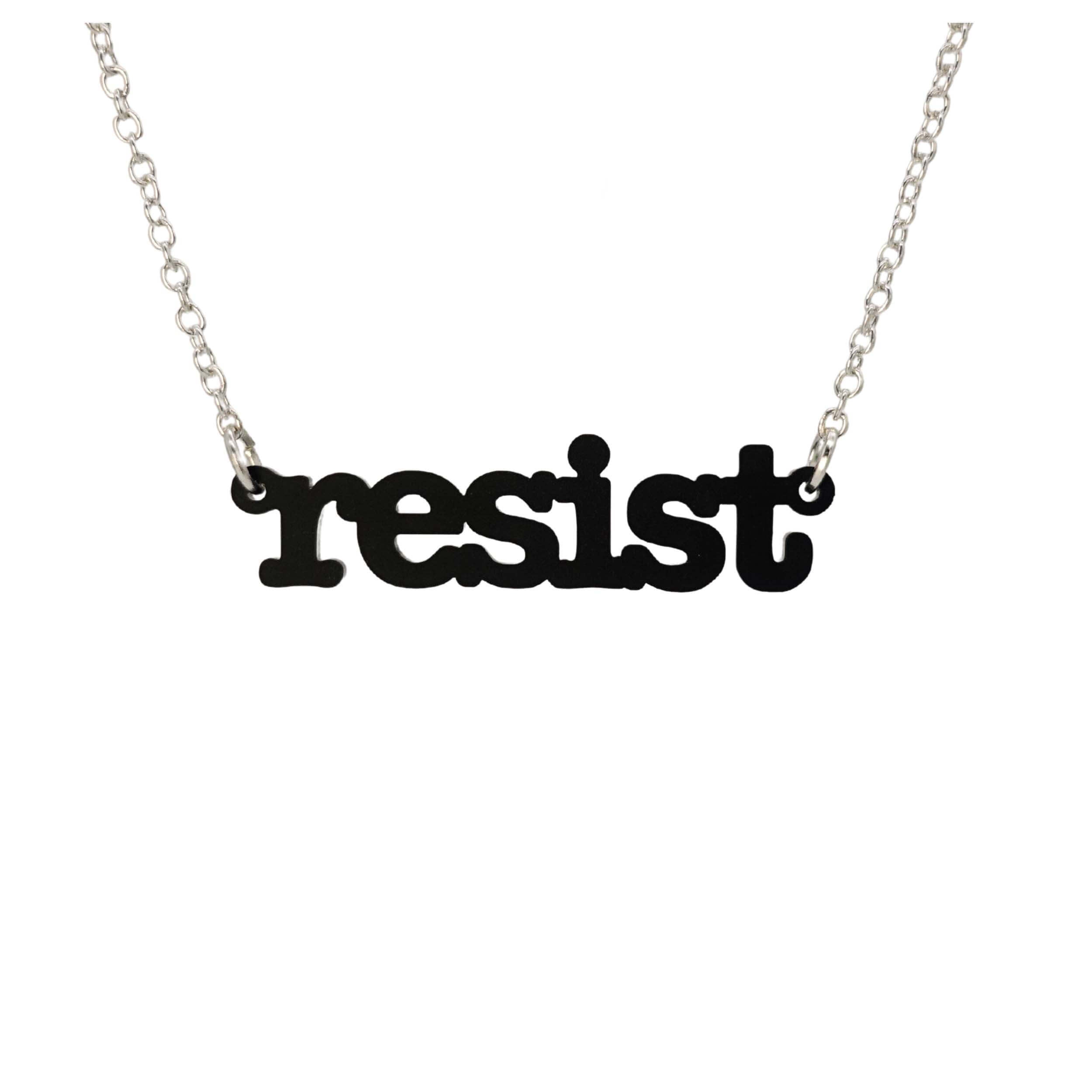 Matte black Resist necklace in typewriter font hanging on a silver chain against a white background.