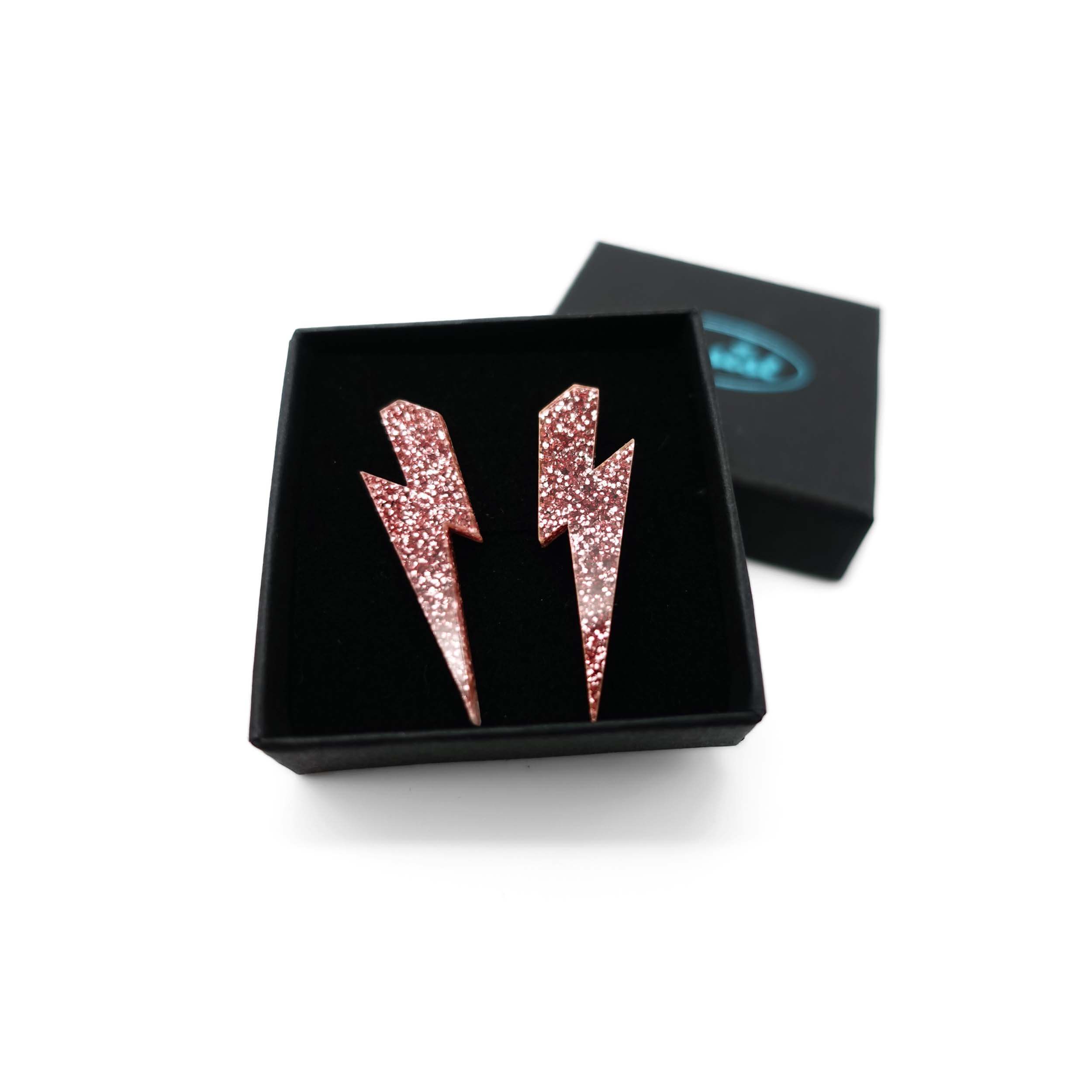 MediumLightning Bolt earrings in rose glitter, shown in a small Wear and Resist gift box.