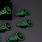F*ck these F*cking F*ckers Megaphone brooch, shown glowing in the dark.