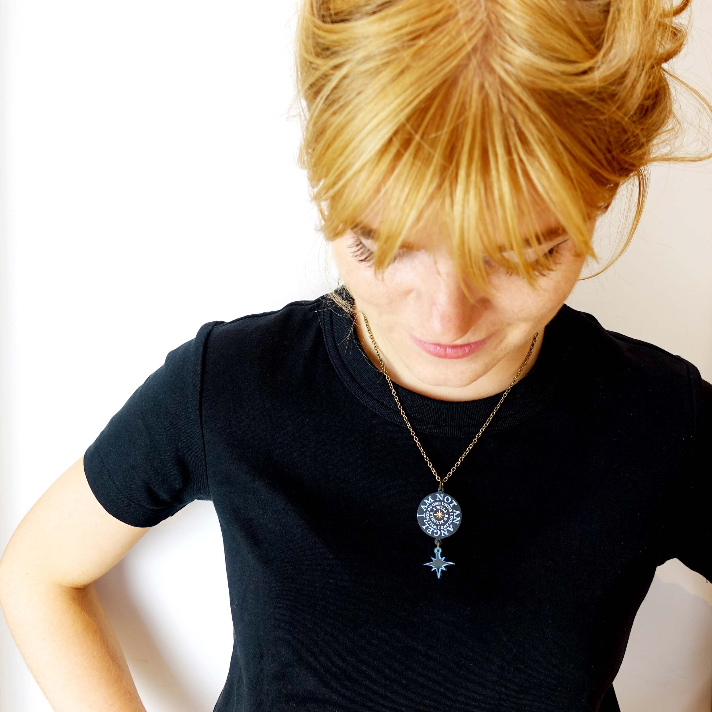Eliza wears the 'I am not an angel' pendant necklace from The Brontë Collection, designed by Sarah Day for Wear and Resist.