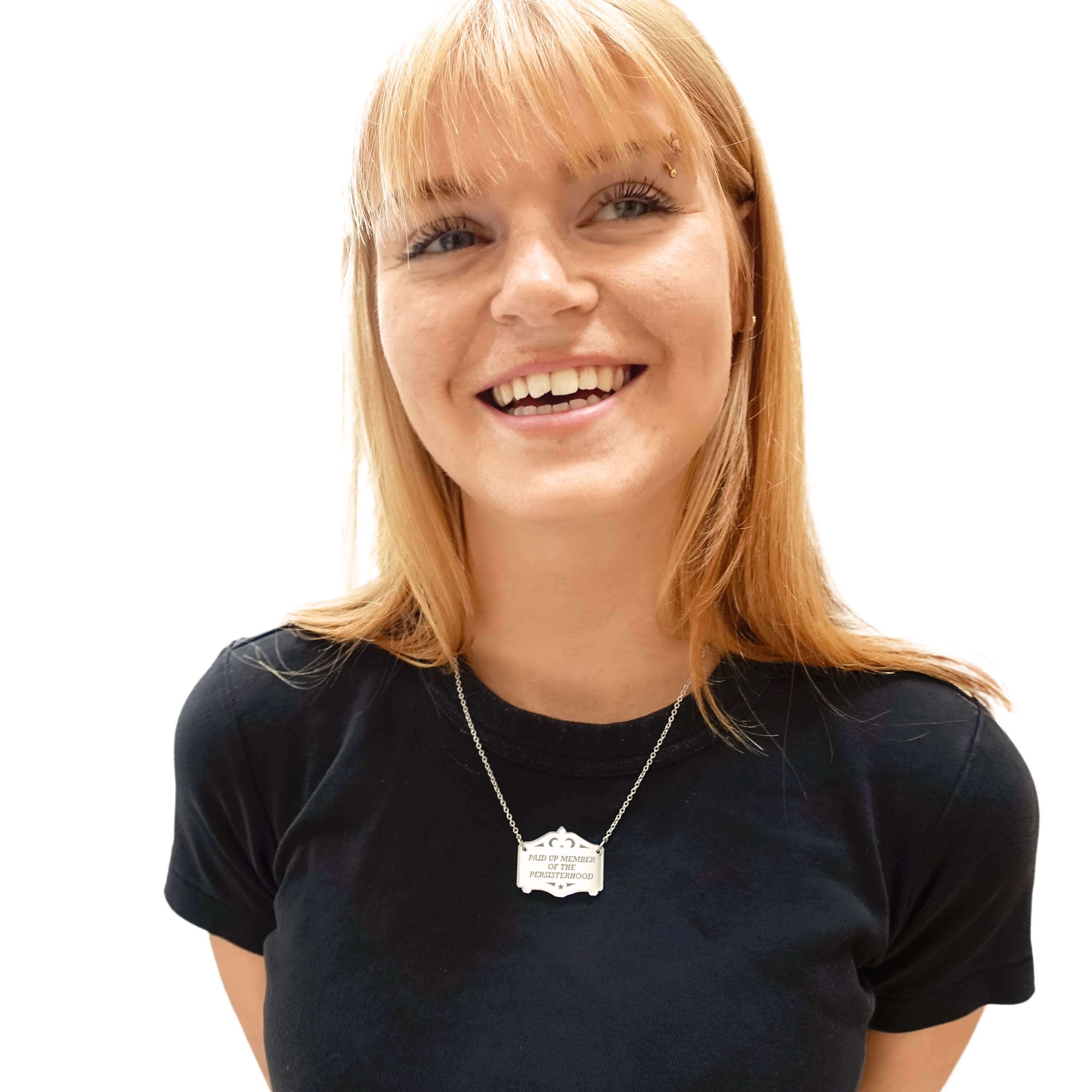 Eliza wears a silver Paid up member of the Persisterhood necklace on a stainless steel chain.