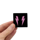 Medium Lightning Bolt earrings in pink mirror, shown held up in a small Wear and Resist gift box.