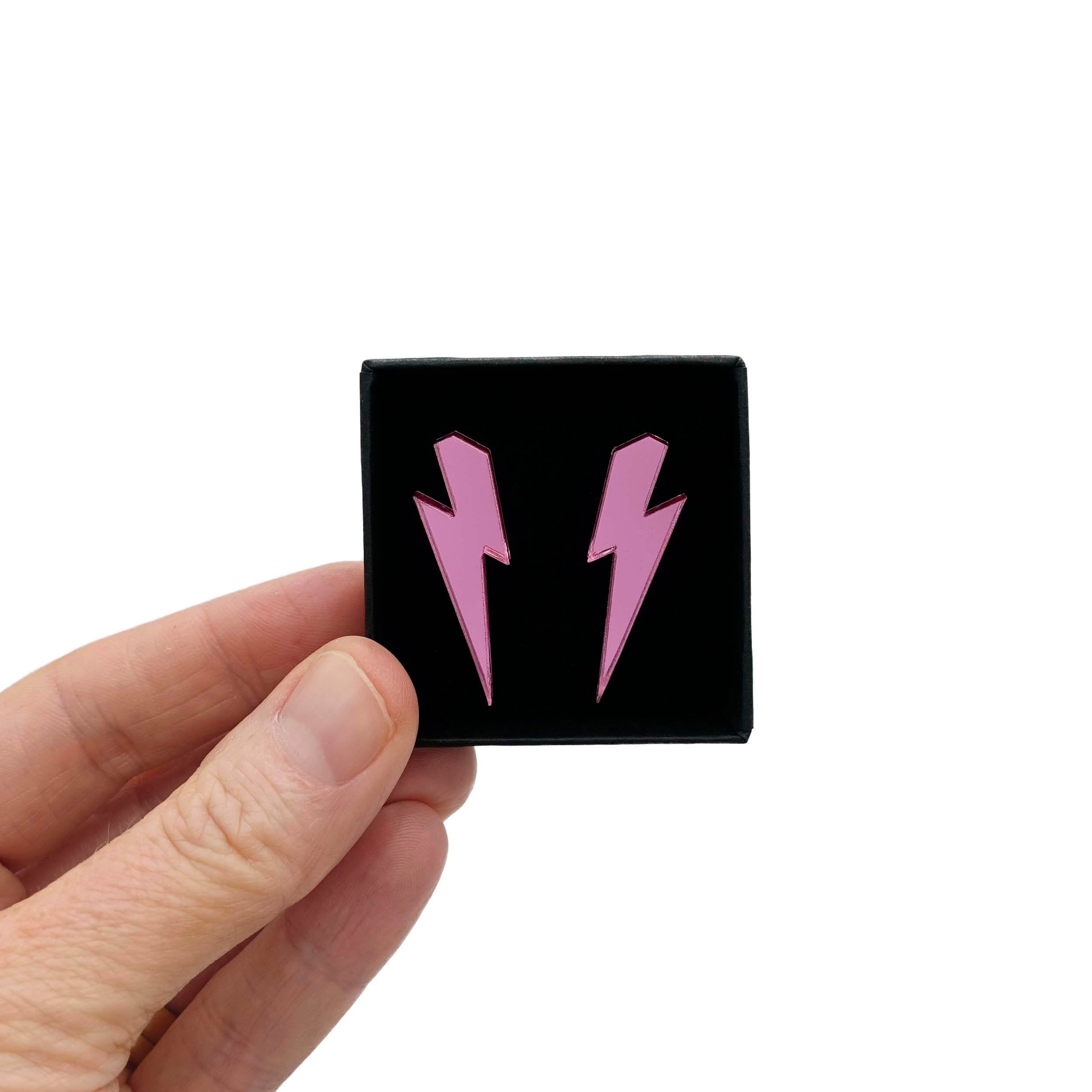 Medium Lightning Bolt earrings in pink mirror, shown held up in a small Wear and Resist gift box.