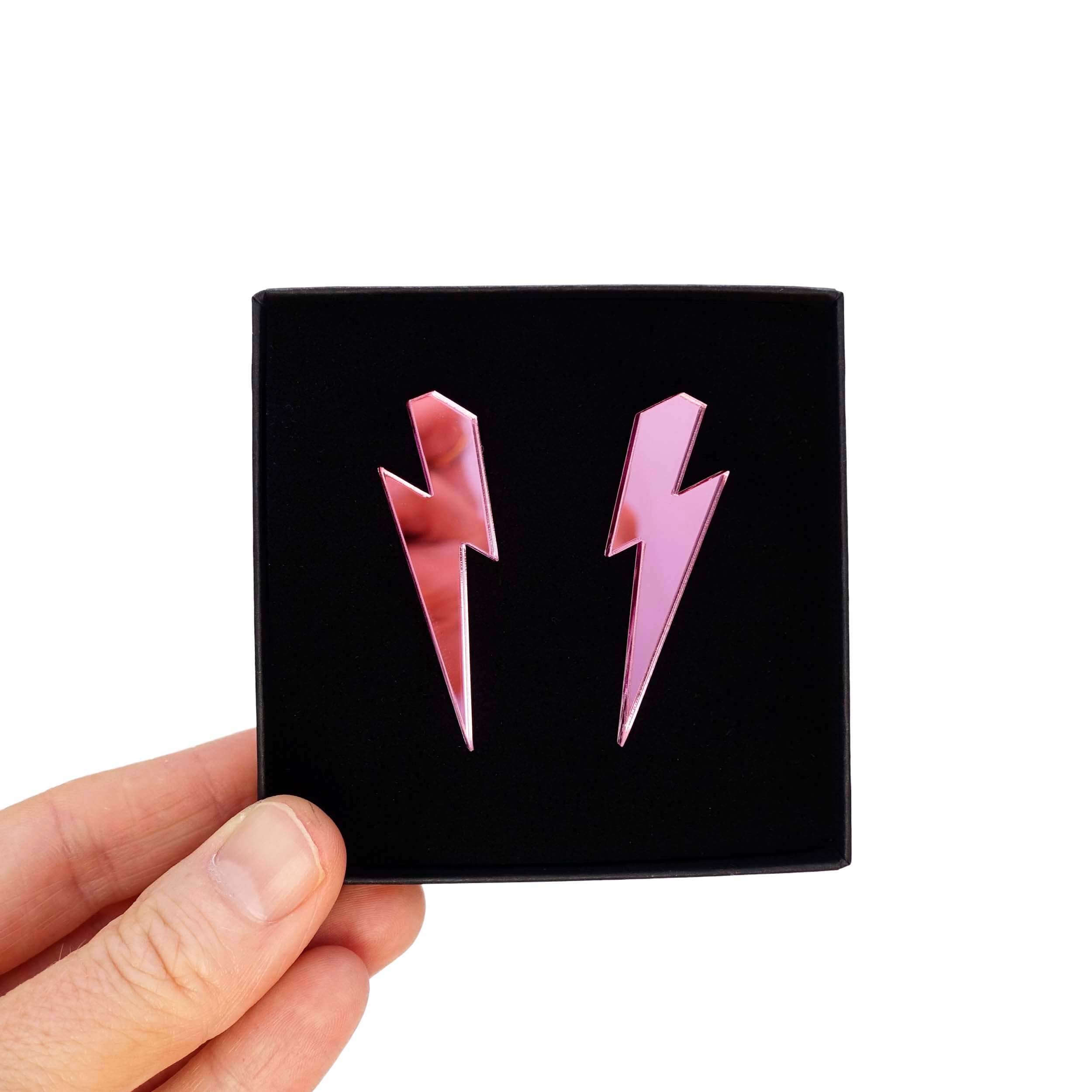 Large Lightning Bolt earrings in pink mirror, shown held up in a Wear and Resist gift box.