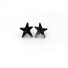 Black glitter funky Wear and Resist star earrings shown on a white background.