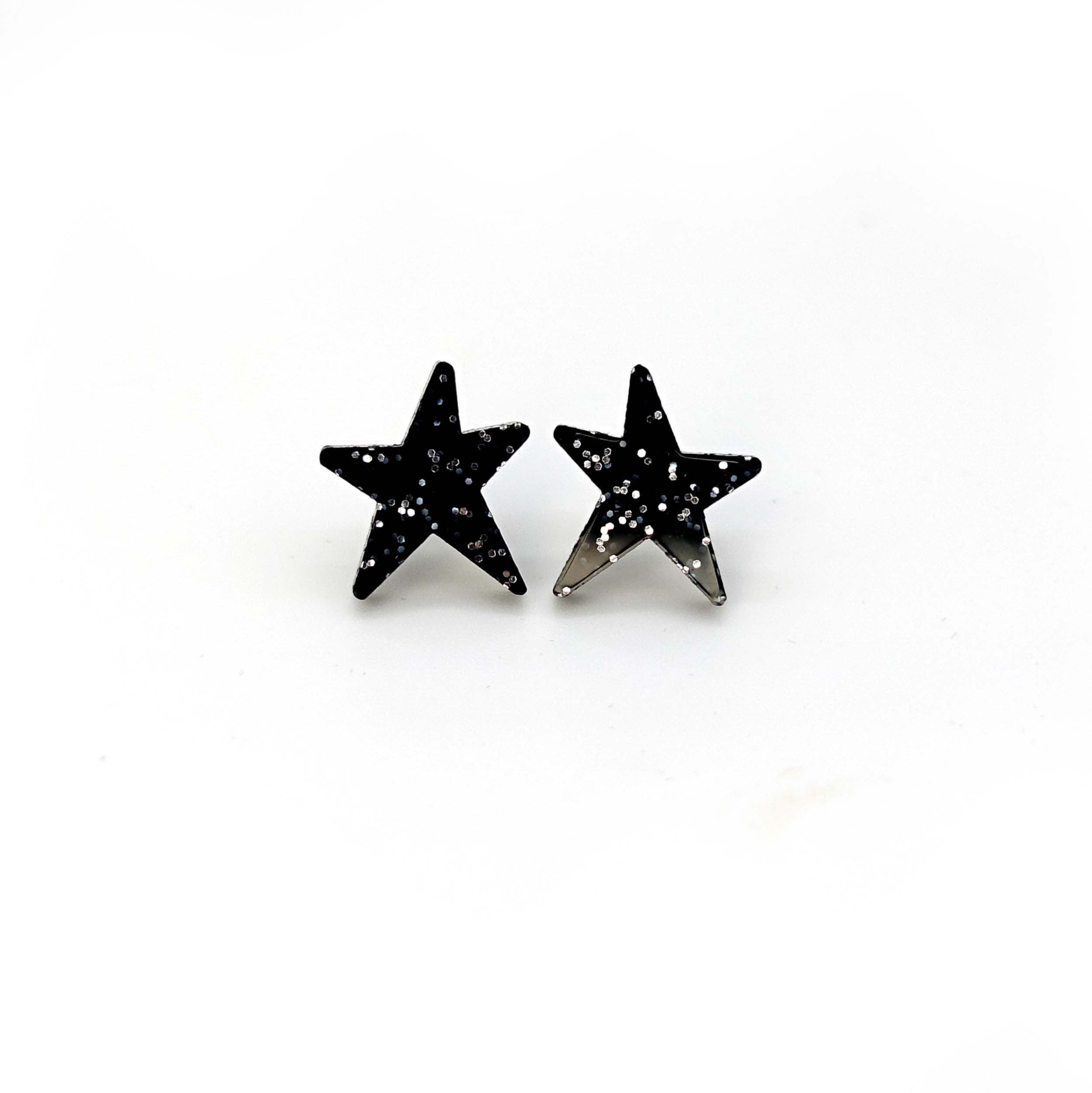 Black glitter funky Wear and Resist star earrings shown on a white background.