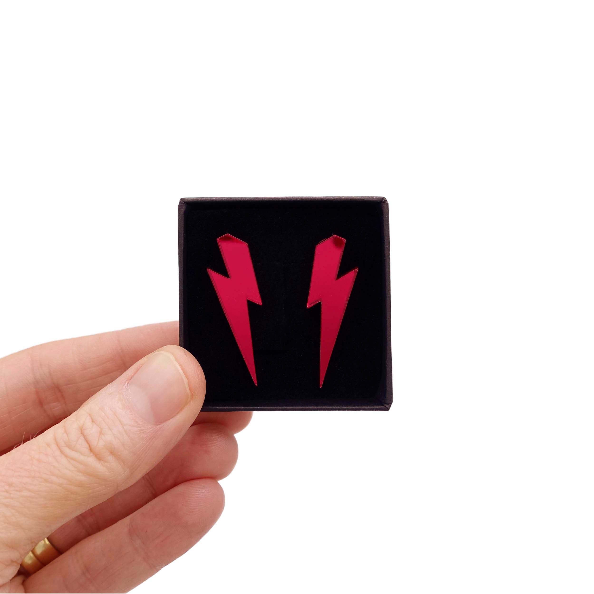 Medium Lightning Bolt earrings in ruby mirror, shown held up in a small Wear and Resist gift box.