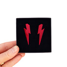 Large Lightning Bolt earrings in ruby mirror, shown held up in a Wear and Resist gift box.