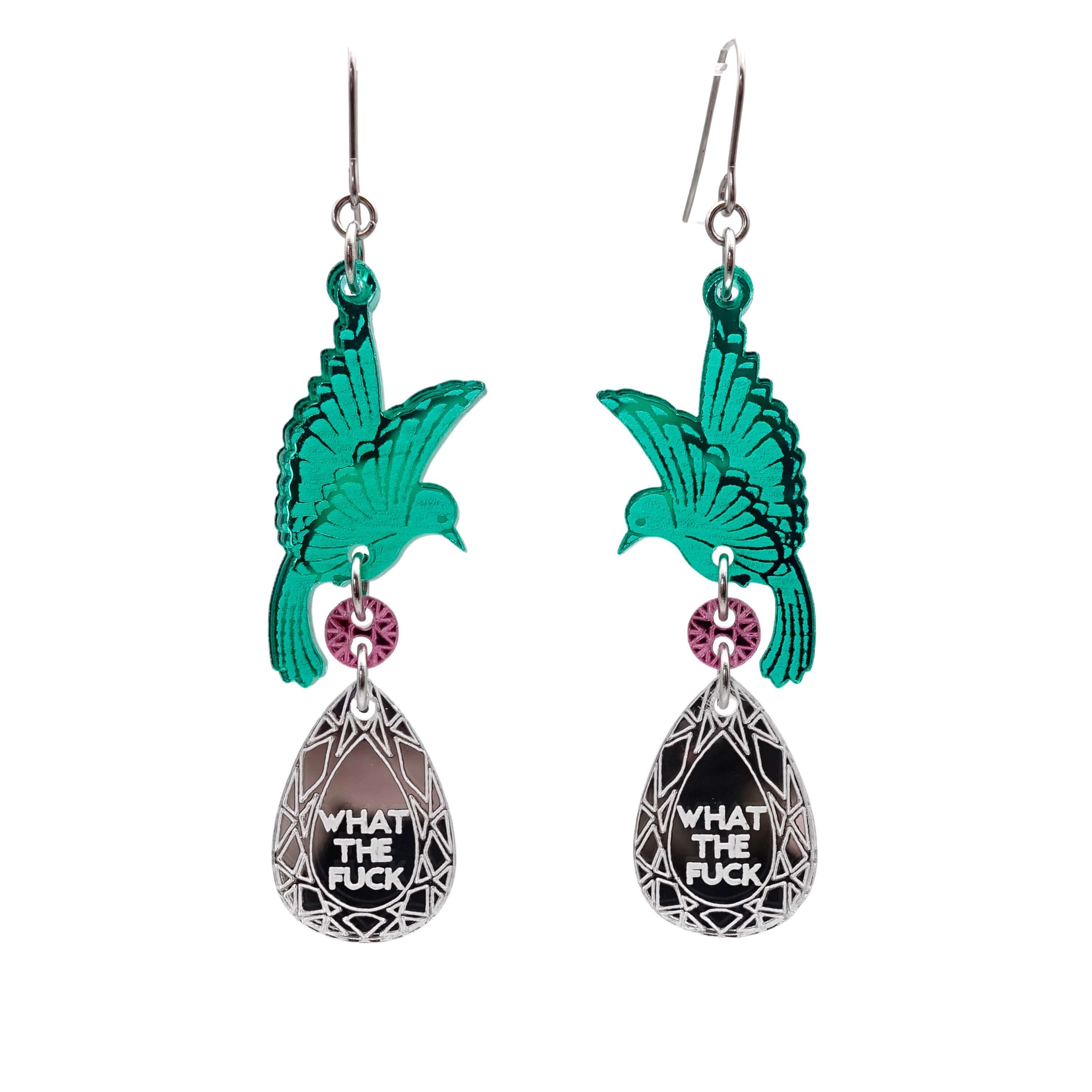 A pair of acrylic earrings with green birds holding silver 'jewels' that say 'What the F*ck'.