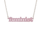 Shell pink Feminist necklace shown hanging on a white background.