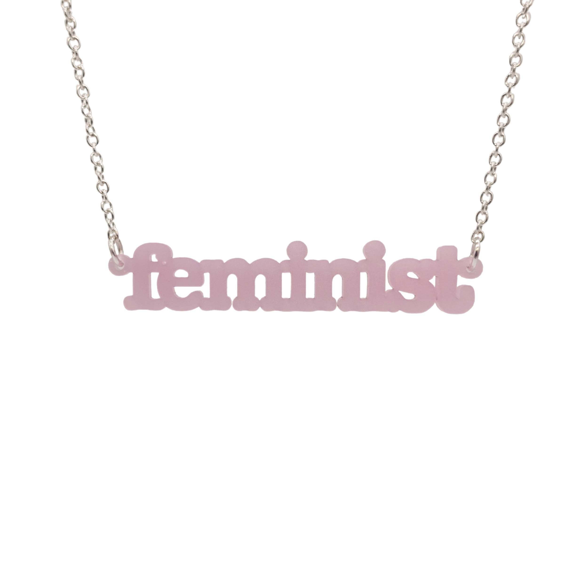 Shell pink Feminist necklace shown hanging on a white background.