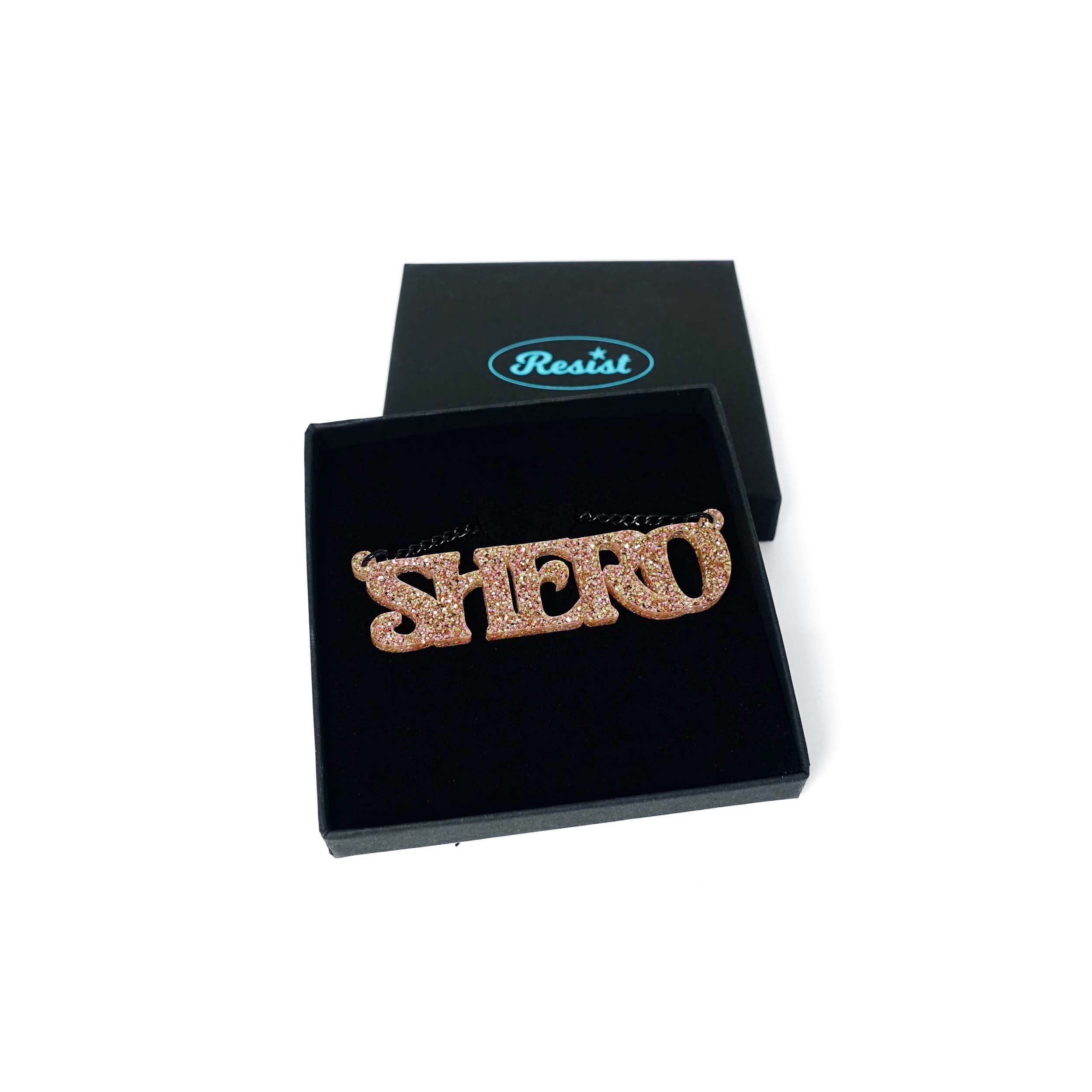 Shero necklace in pink fizz glitter shown in a Wear and Resist gift box.