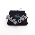 Woke AF necklace in silver glitter shown on a Wear and Resist gift box.