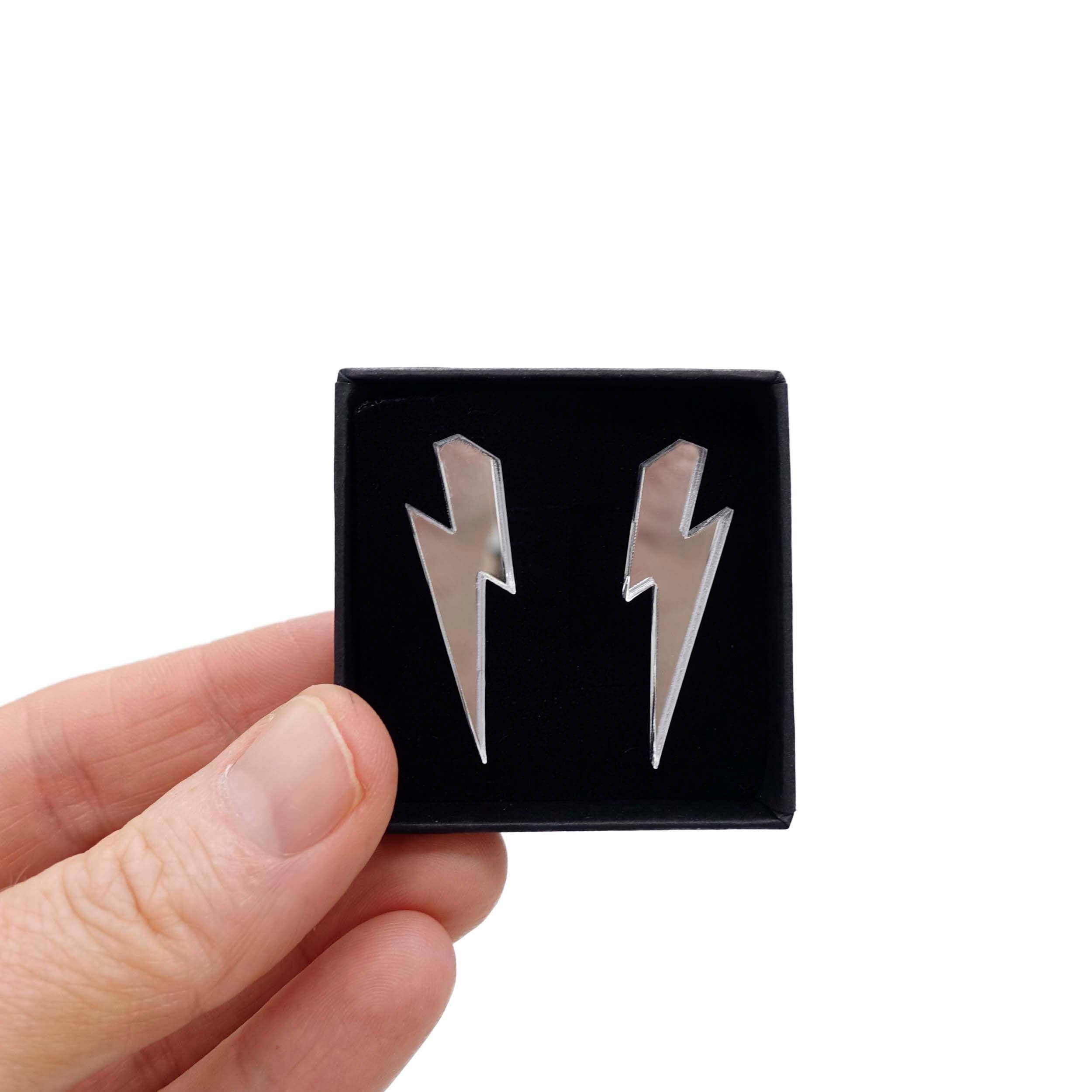 Medium Lightning Bolt earrings in silver mirror, shown held up in a small Wear and Resist gift box.