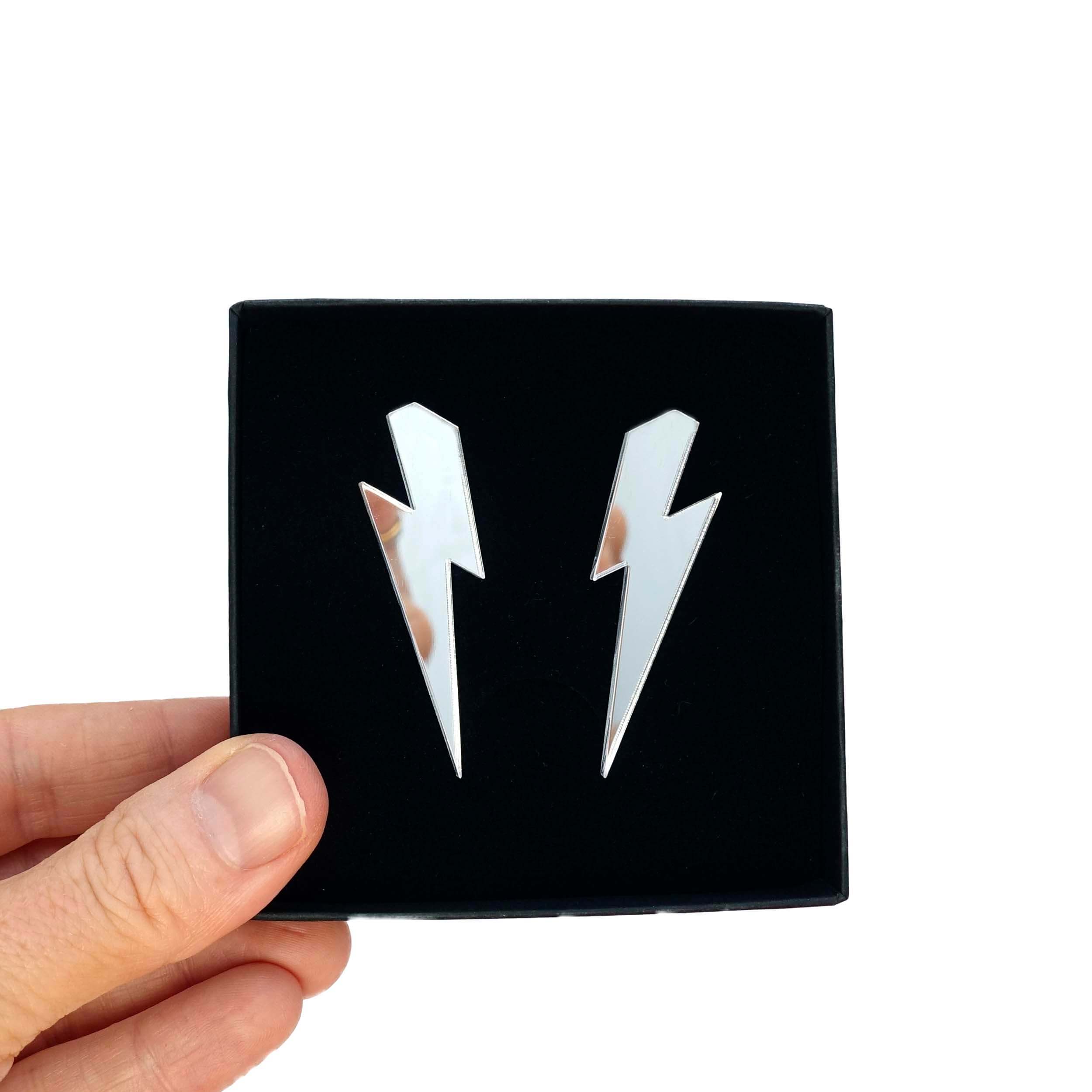 Large Lightning Bolt earrings in silver mirror, shown held up in a Wear and Resist gift box.