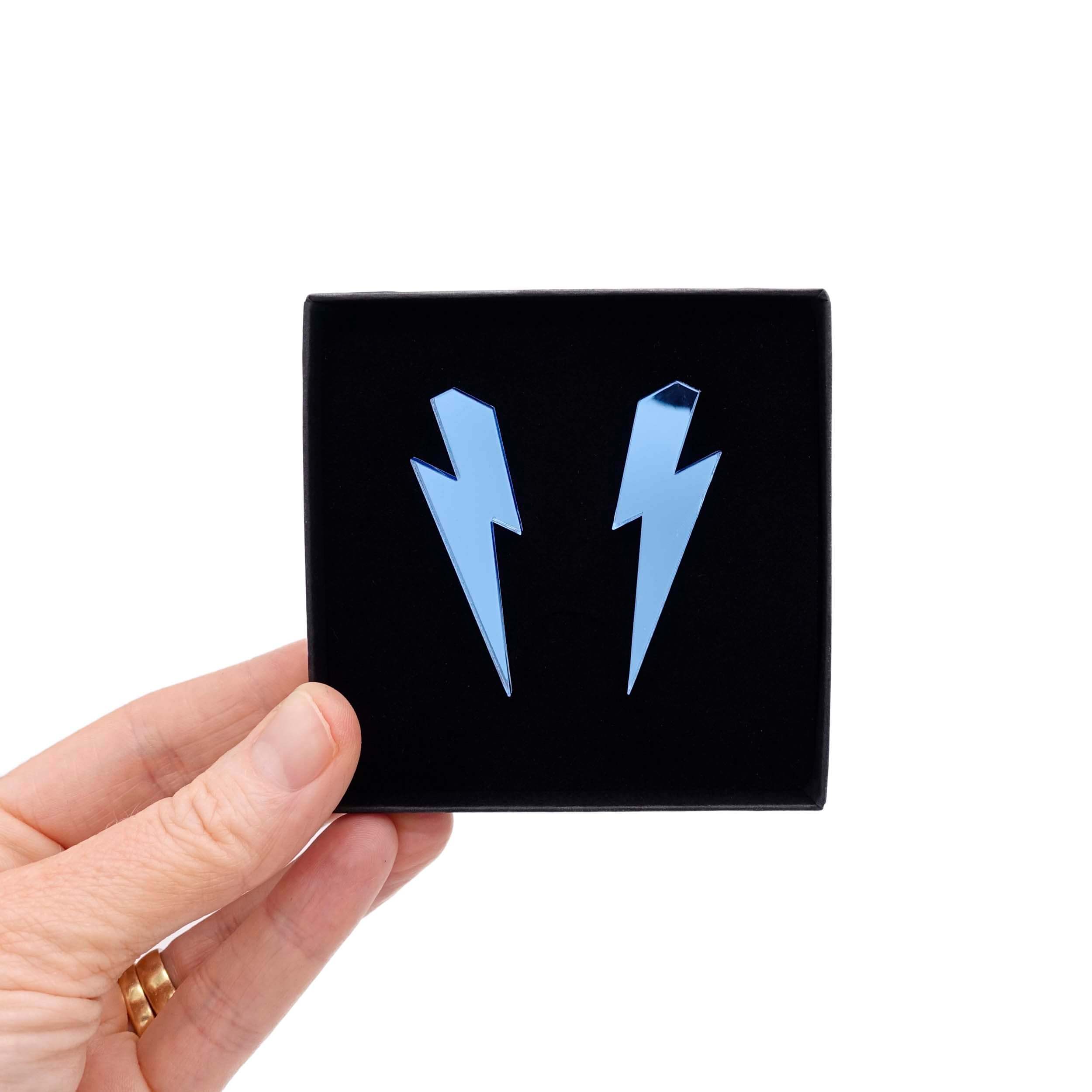 Large Lightning Bolt earrings in sky blue mirror, shown held up in a Wear and Resist gift box.