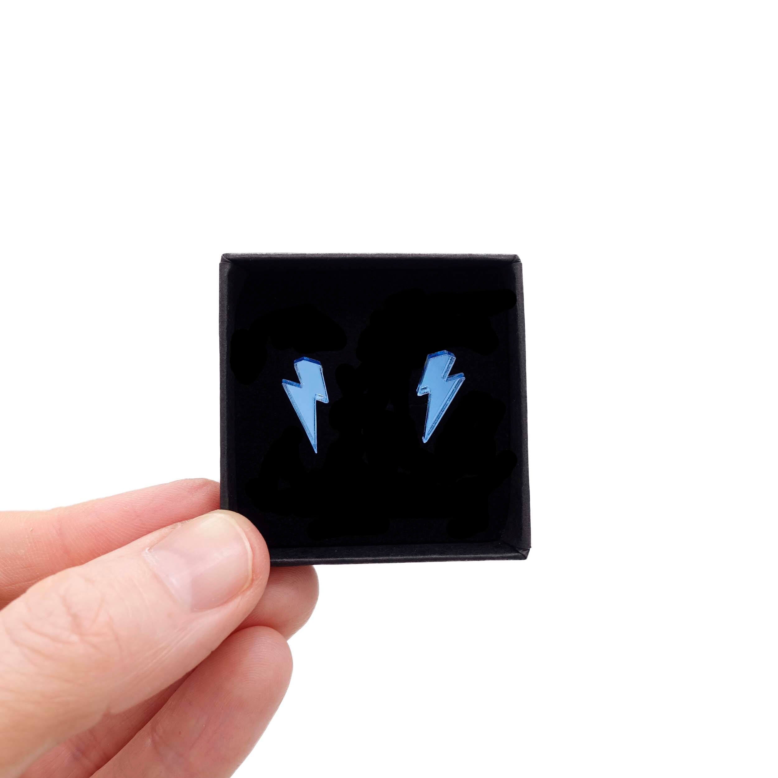 Tiny Lightning Bolt earrings in skyt mirror, shown held up in a small Wear and Resist gift box.