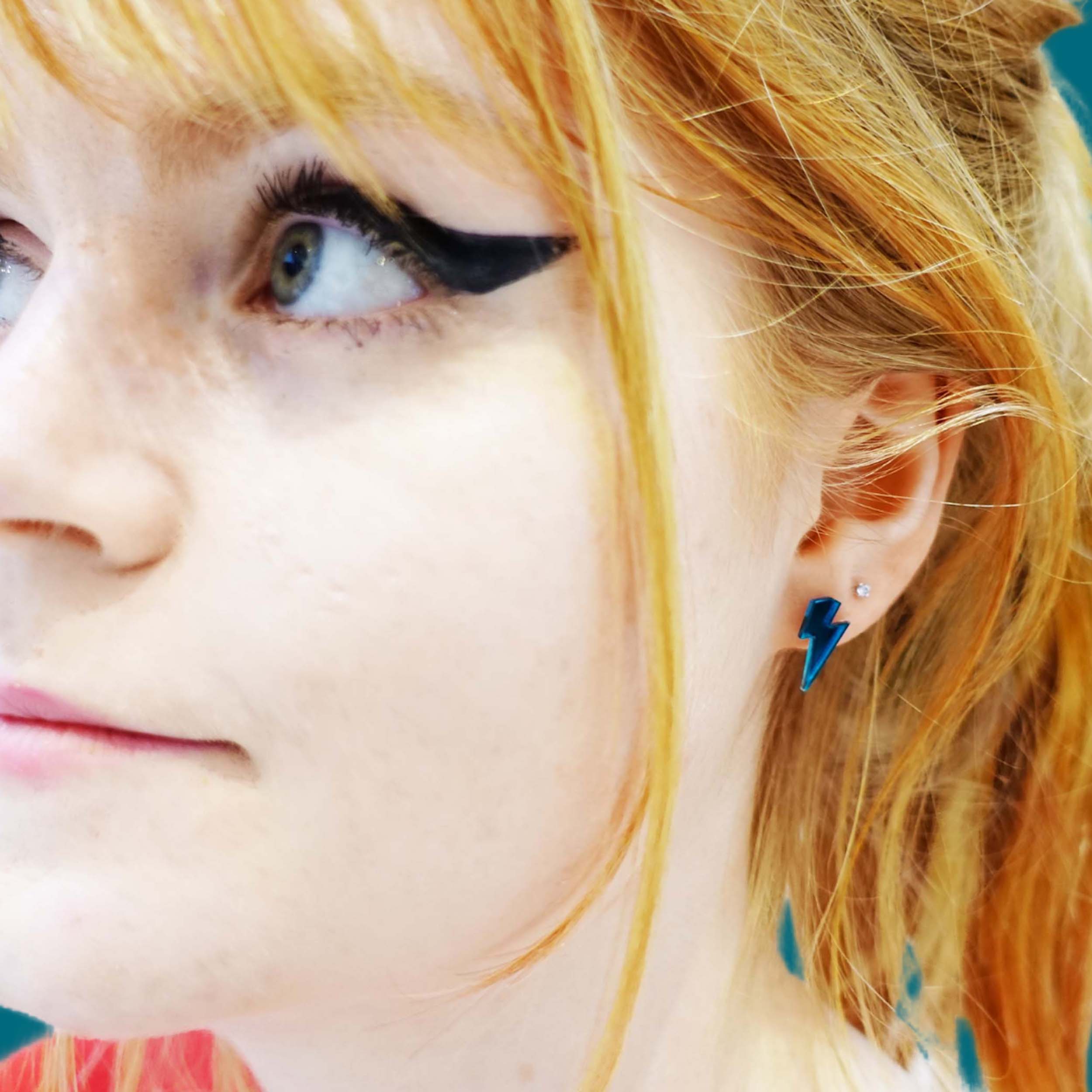 Eliza wears tiny Lightning Bolt earrings in slate mirror.