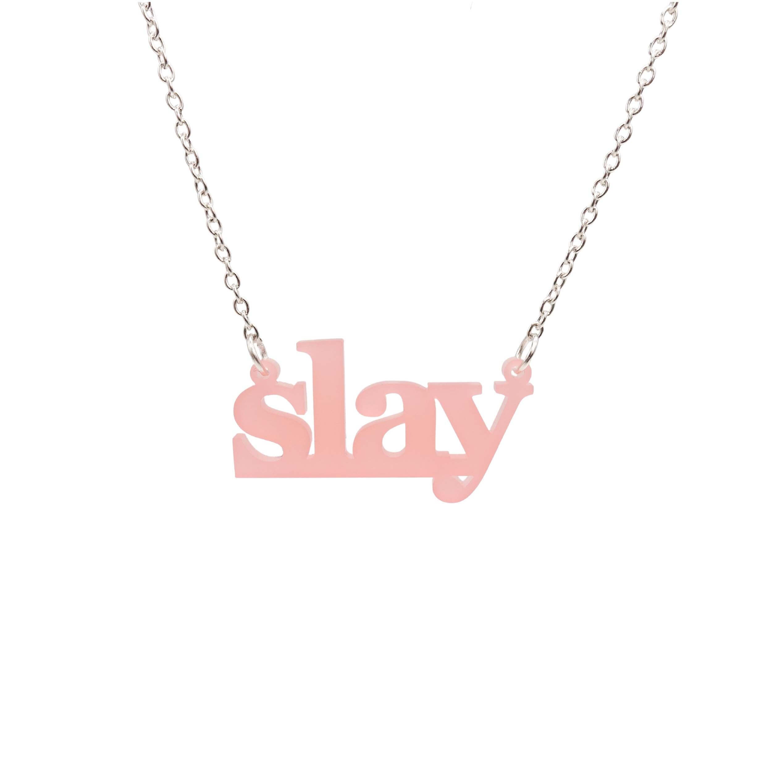 Slay necklace in blush pink on a silver chain shown hanging against a white background. Designed by Sarah Day for Wear and Resist. £2 goes to Women for Refugee Women charity.