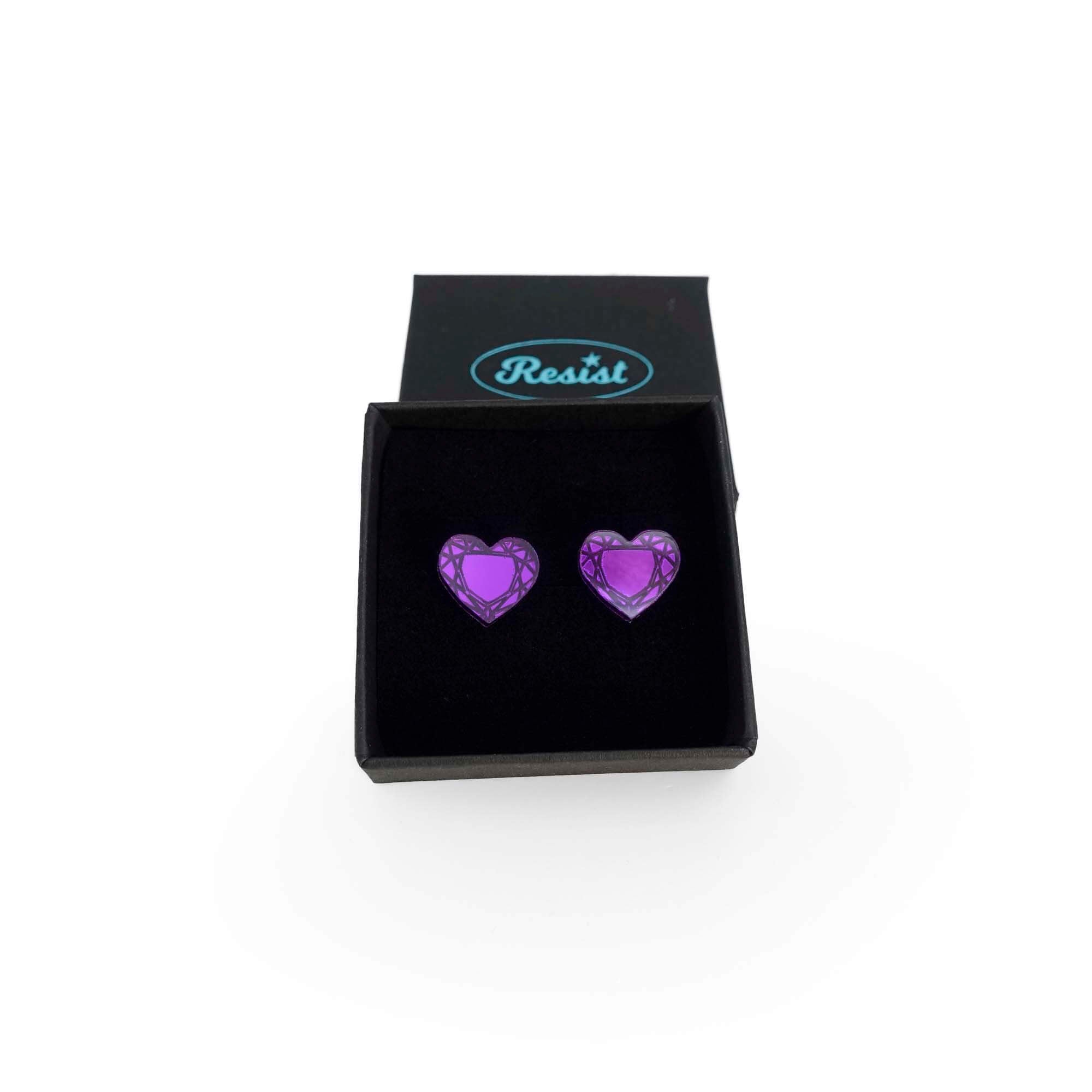 Purple heart stud earrings shown in a Wear and Resist gift box.