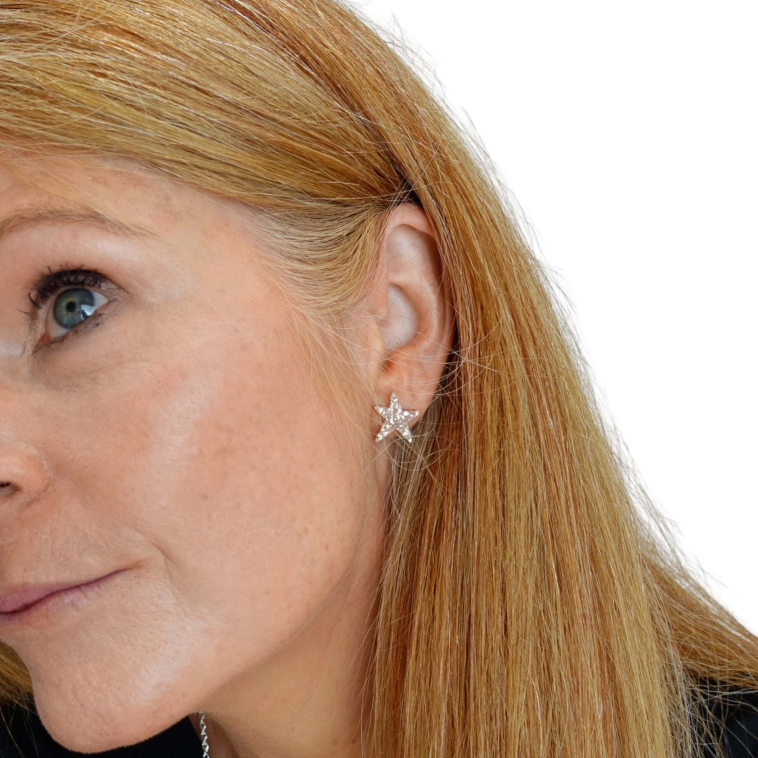 Sarah Day wears funky Resist star earrings in gold glitter.