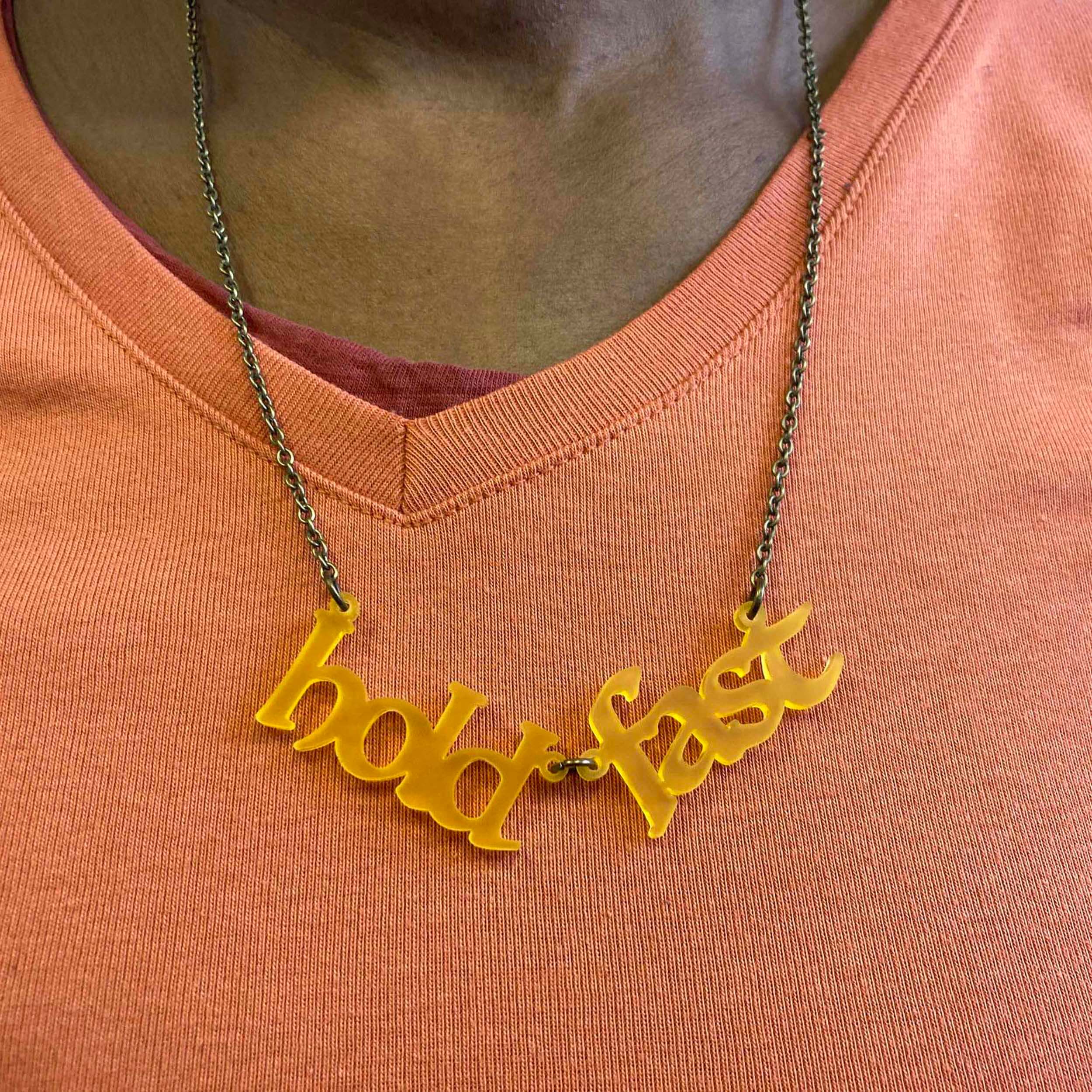 A member of Women for Refugee Women wears a sunflower frost Hold Fast necklace. 