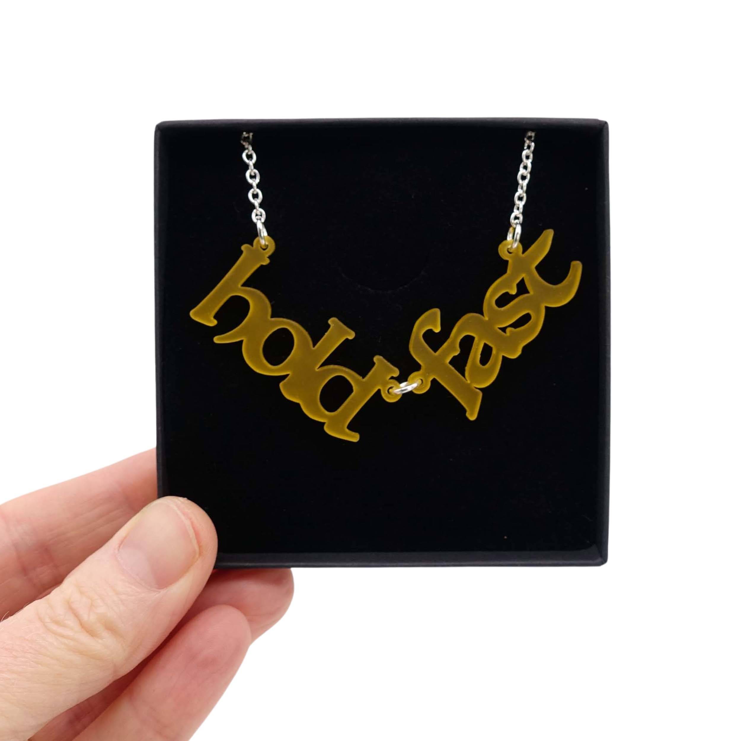Hold Fast necklace in sunflower frost shown held up in a Wear and Resist gift box. 