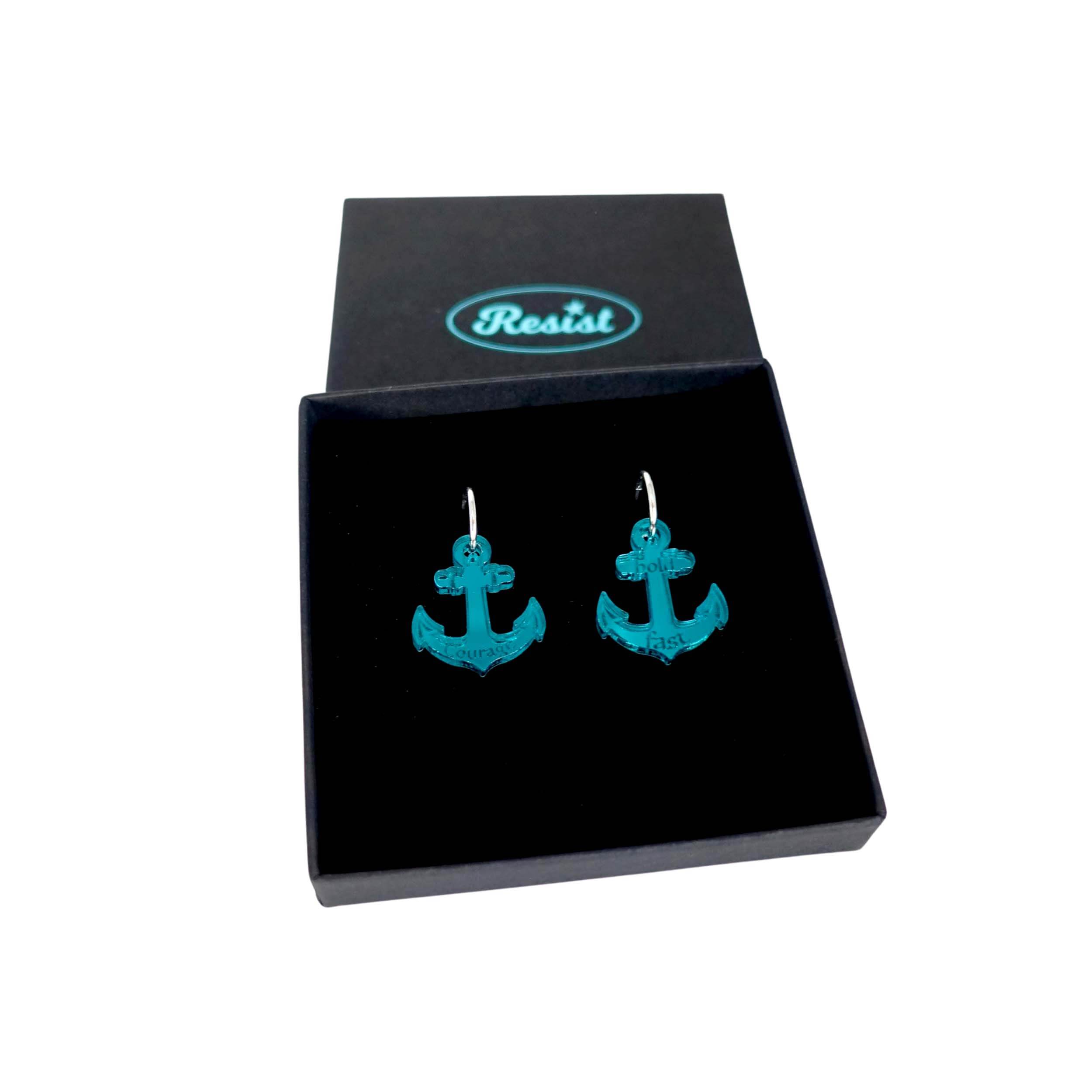 Medium anchor earrings in teal etched with the words 'courage' on one and 'hold fast' on the other. Shown in a Wear and Resist gift box.