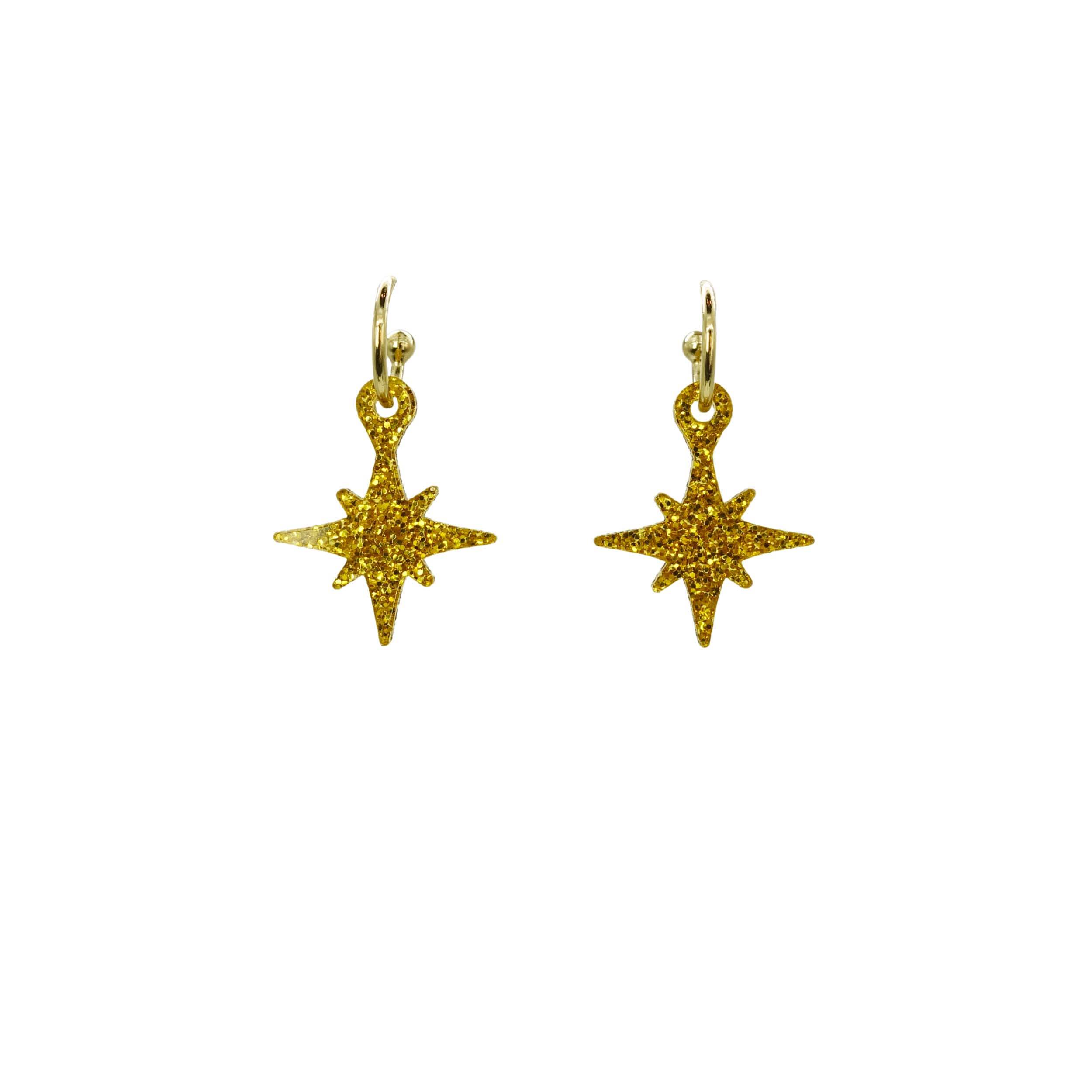 Ultra gold glitter vintage star earrings on hoops shown hanging on a white backround.