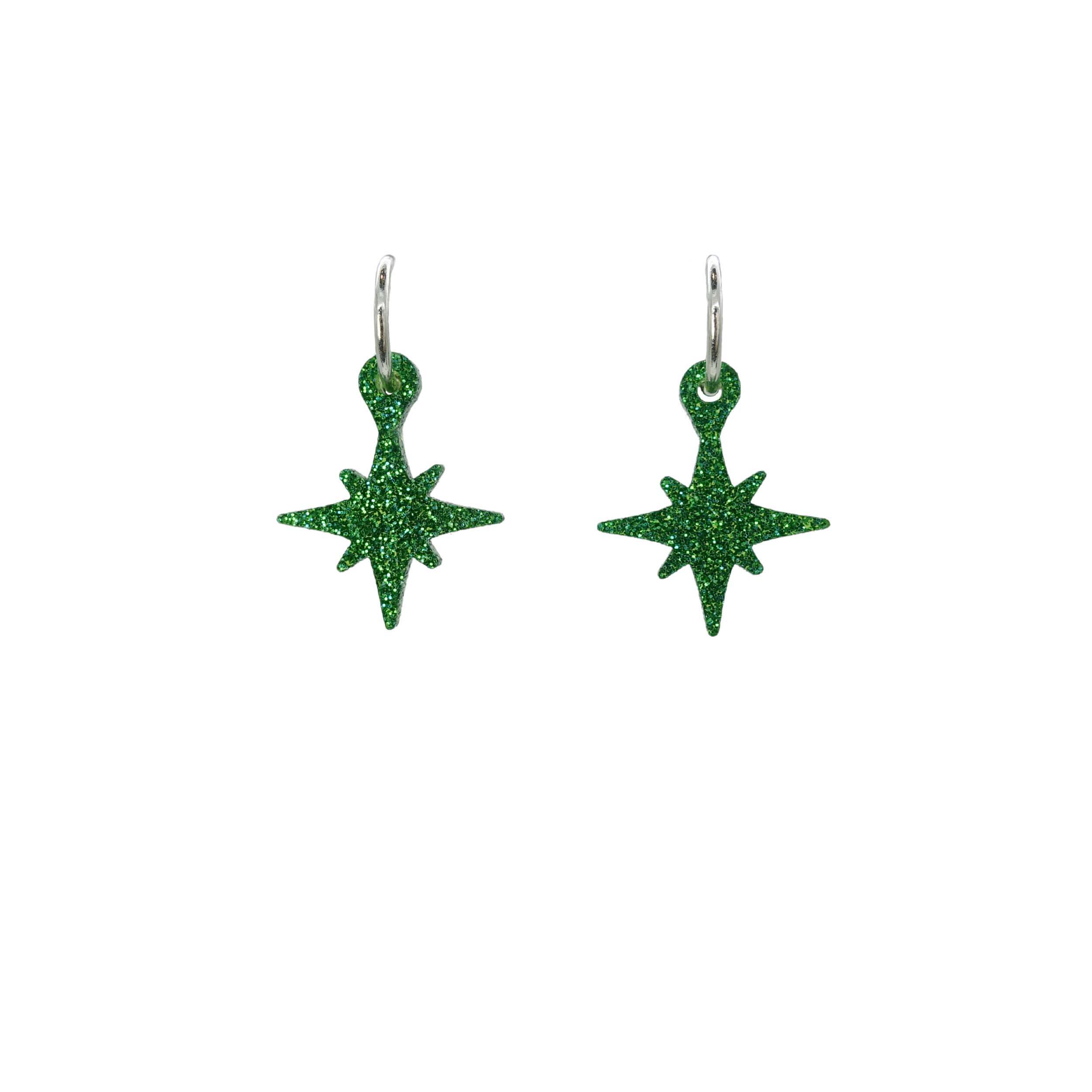 Green glitter vintage star earrings on hoops shown hanging on a white backround.