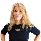 Sarah wears a gold glitter big Witch necklace.