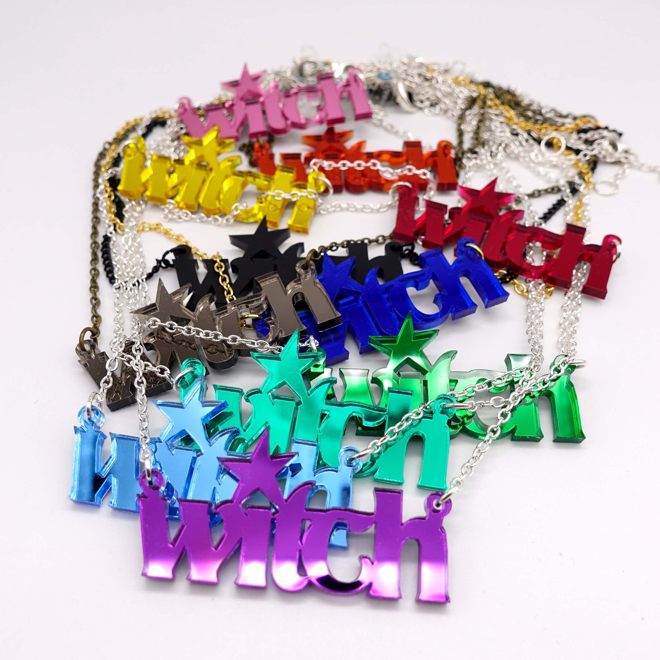 All of the Witch necklaces shown strewn together on a white background.